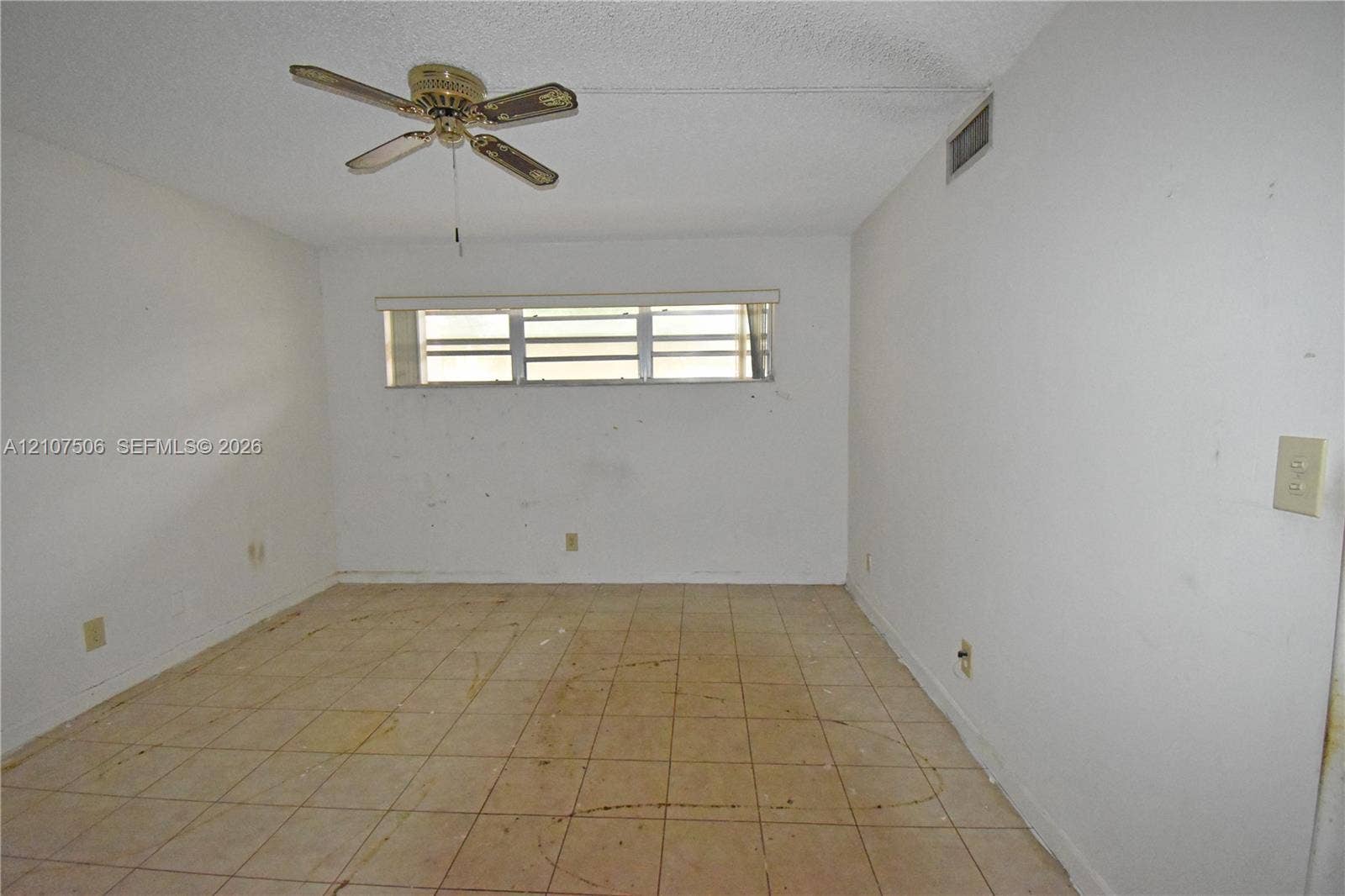 830 S Hollybrook Drive, #207, Pembroke Pines, FL 33025 Interior room featuring tiled flooring, a horizontal slider window with window blinds, and a ceiling-mounted fan
