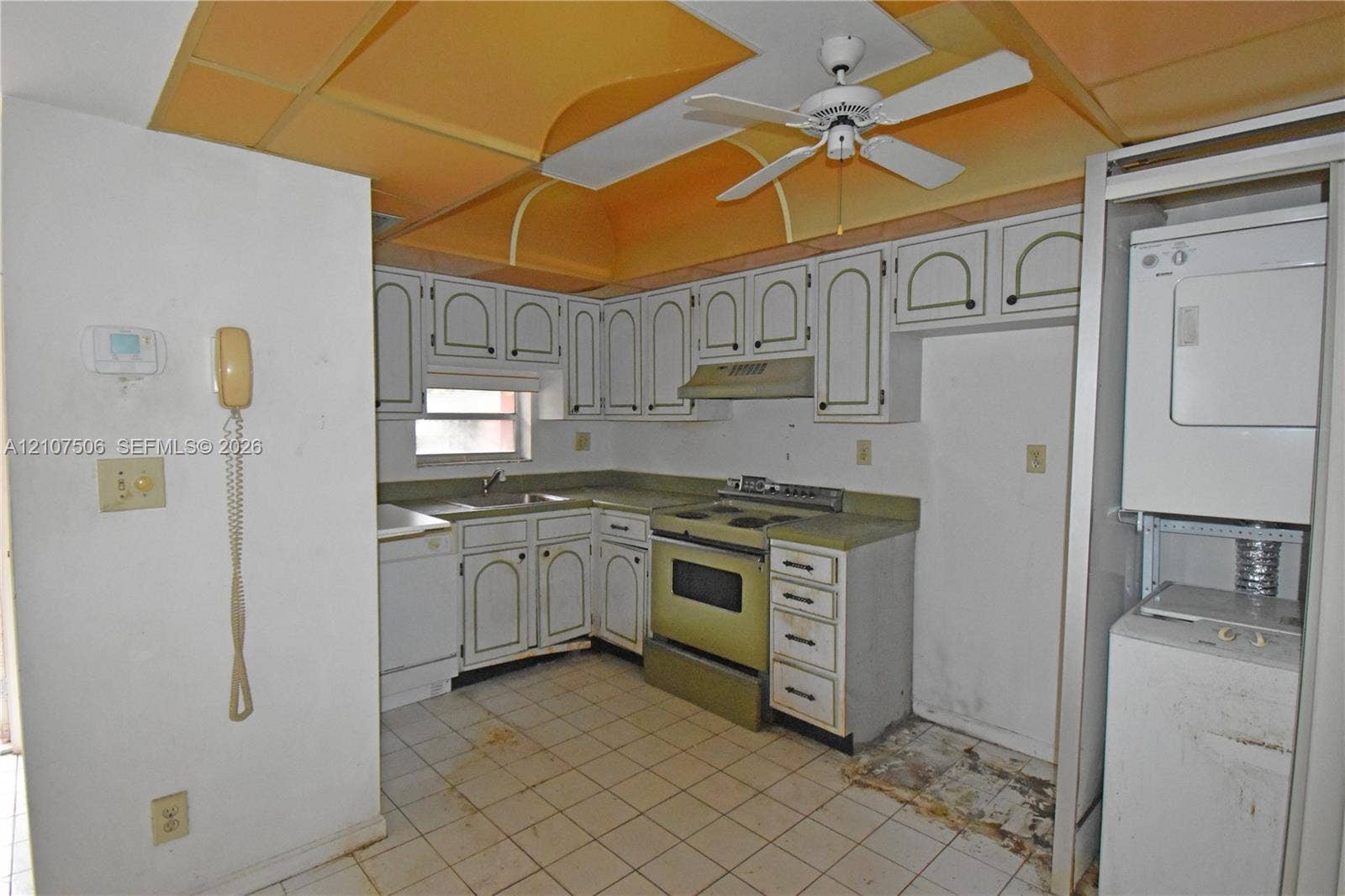 830 S Hollybrook Drive, #207, Pembroke Pines, FL 33025 Kitchen featuring white cabinetry with decorative molding, integrated white ceiling fan, tile flooring, and a built-in laundry station