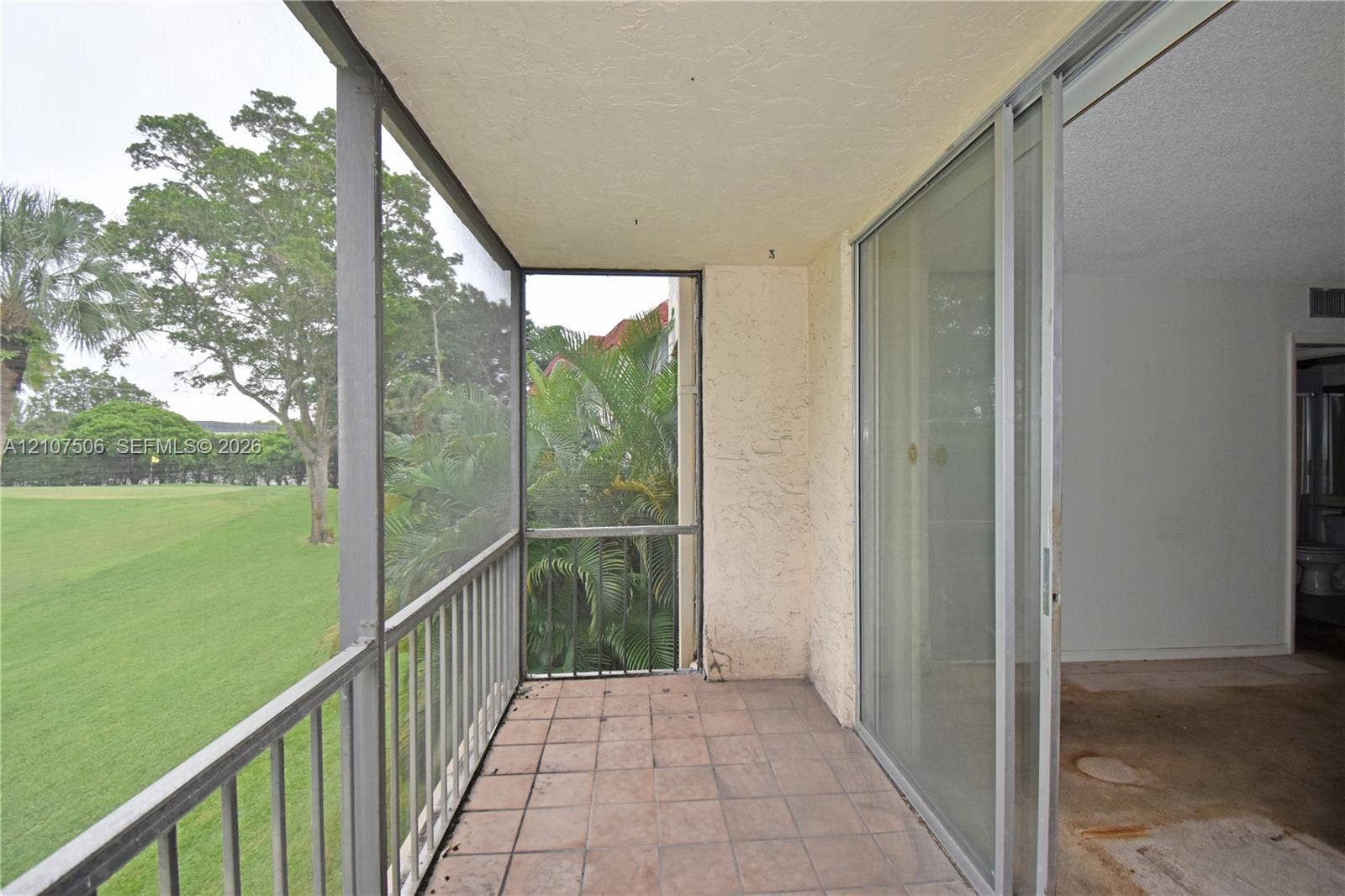 830 S Hollybrook Drive, #207, Pembroke Pines, FL 33025 Screened-in balcony featuring tile flooring, metal railings, and sliding glass doors
