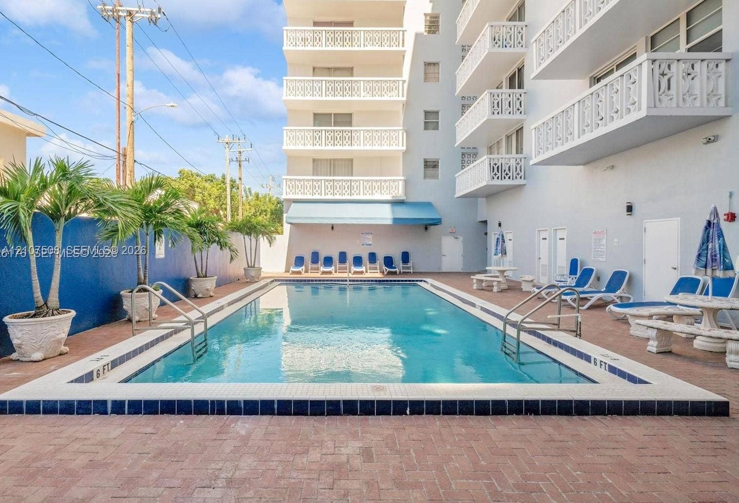 1020 Meridian Avenue, #415, Miami Beach, Miami Beach, FL 33139 In-ground swimming pool with tile surround, red brick paver decking, and potted palm trees