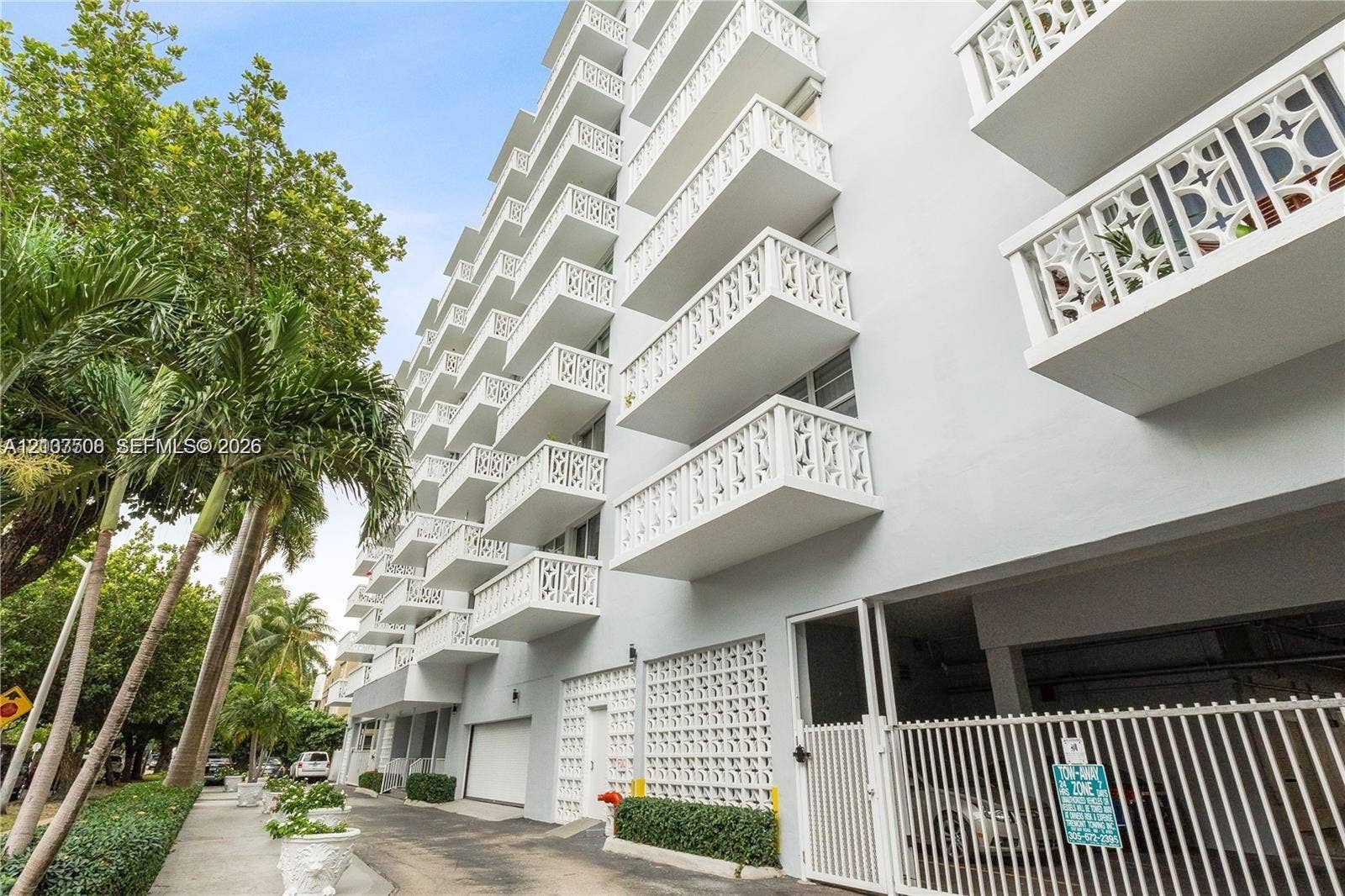 1020 Meridian Avenue, #415, Miami Beach, Miami Beach, FL 33139 Multi-story exterior featuring tiered balconies with decorative lattice railings, structural concrete facade, and integrated ground-level parking
