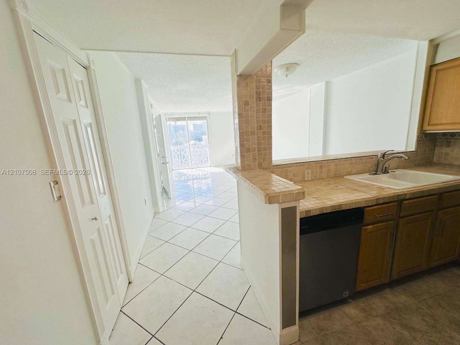 1020 Meridian Avenue, #415, Miami Beach, Miami Beach, FL 33139 Kitchen featuring tile countertops, mosaic tile backsplash, wood-finish cabinetry, a built-in dishwasher, and white ceramic tile flooring