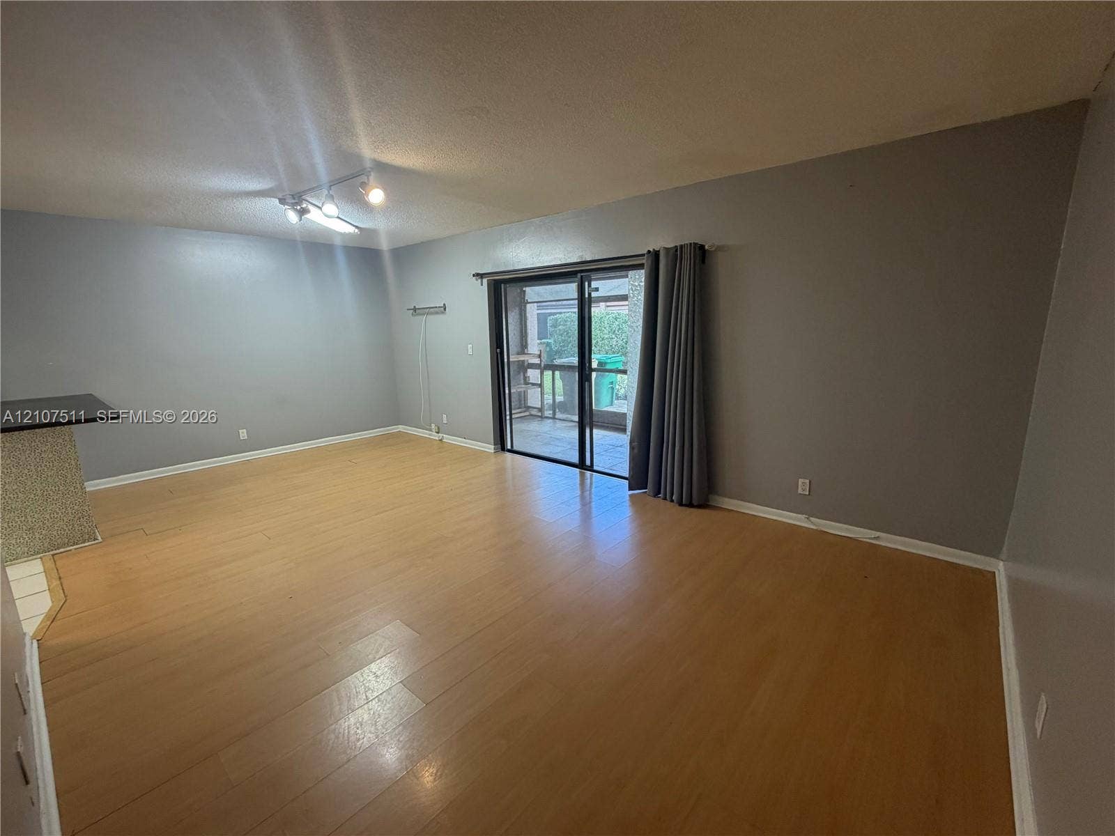 12 S Valencia Drive, #5-4, Davie, FL 33324 Living area featuring wood-finish flooring, sliding glass patio doors, and multi-directional track lighting