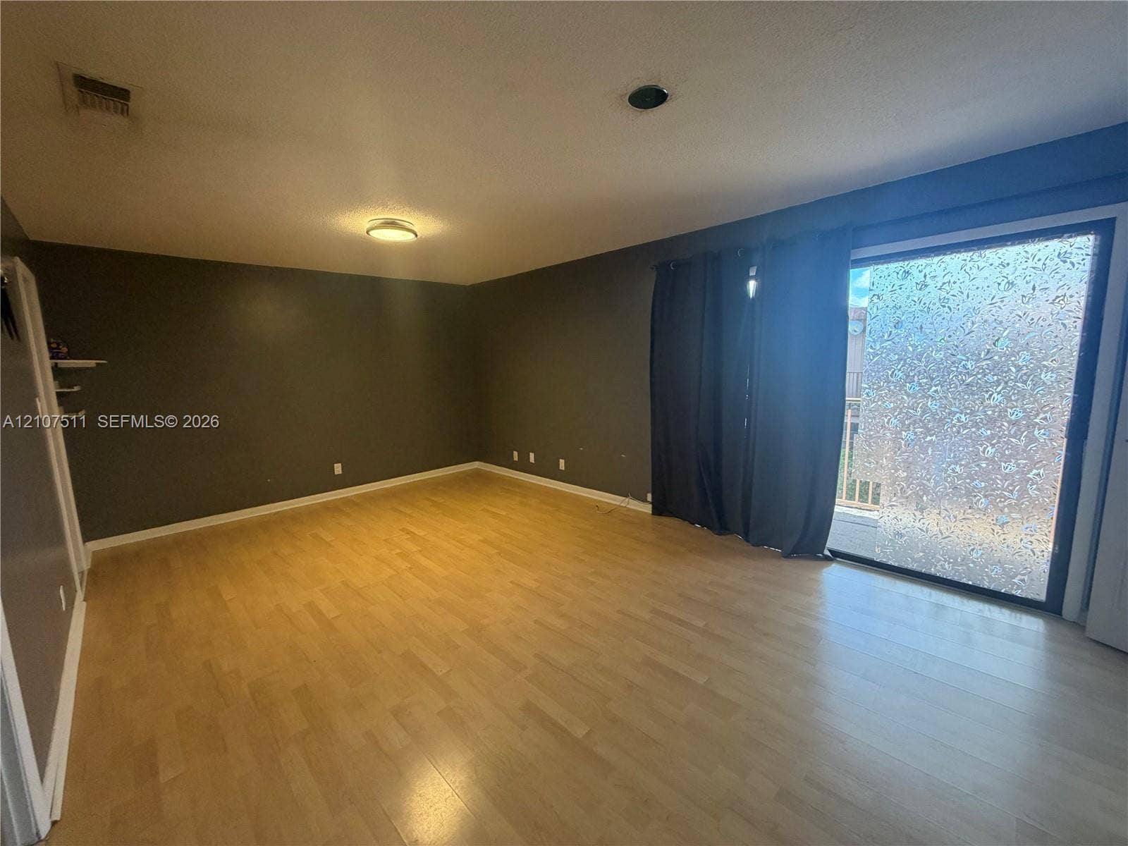 12 S Valencia Drive, #5-4, Davie, FL 33324 Interior room featuring wood-finish flooring, neutral wall tones, and glass sliding doors