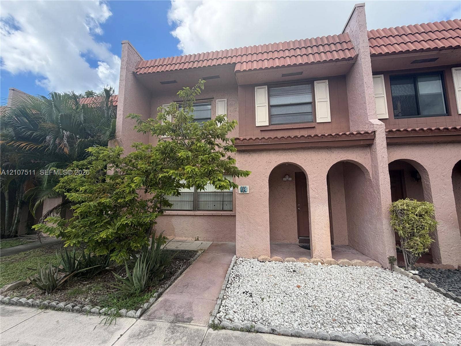 12 S Valencia Drive, #5-4, Davie, FL 33324 Stucco exterior featuring arched entryways, decorative shutters, and a tile roof