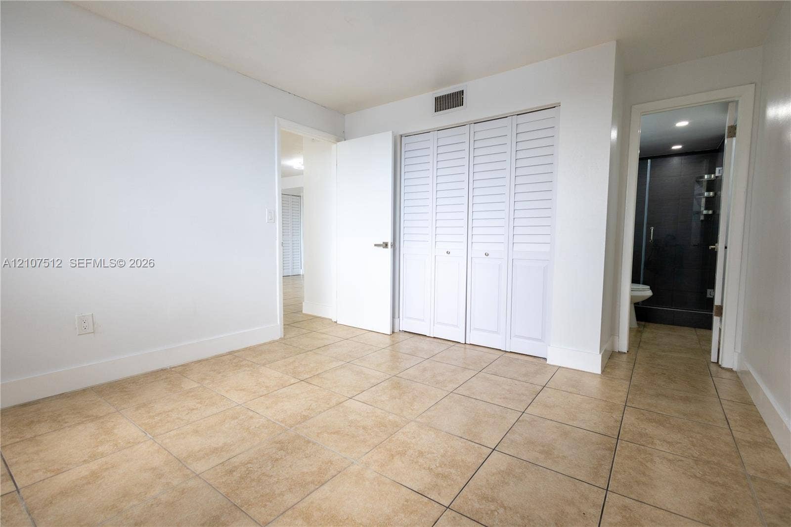 1720 N River Drive, #302, Miami, FL 33125 Neutral-toned tile flooring, built-in closet with louvered doors, and recessed ceiling lighting