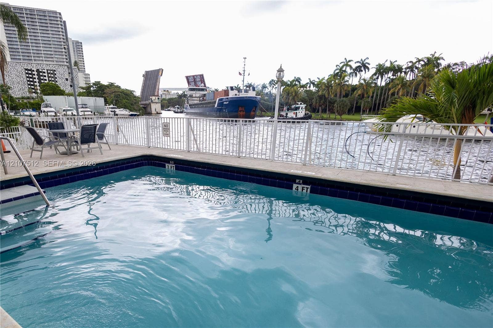 1720 N River Drive, #302, Miami, FL 33125 Swimming pool with tile surround, white metal railing, and concrete deck
