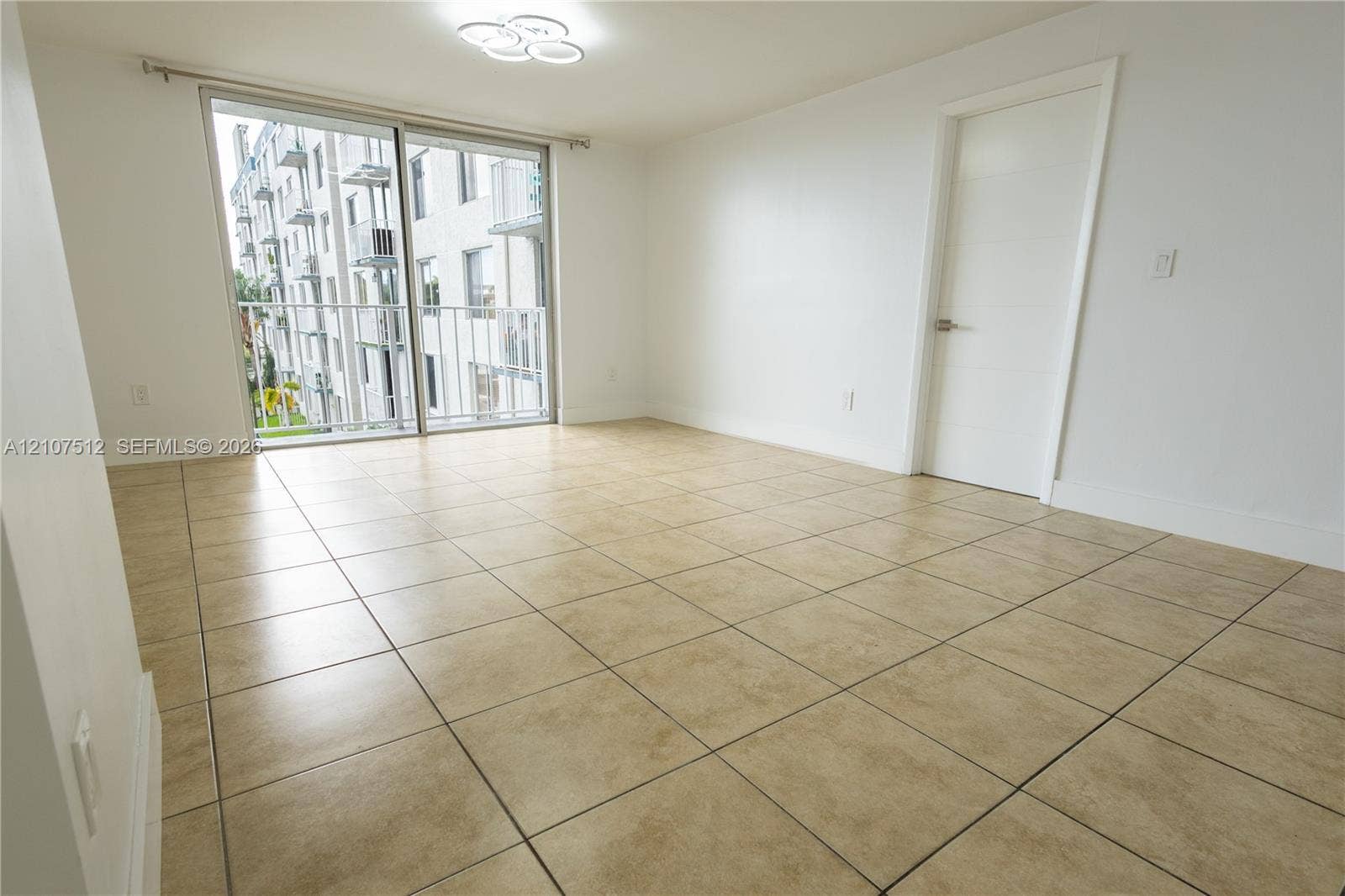 1720 N River Drive, #302, Miami, FL 33125 Large-format tile flooring, sliding glass door, metal-railed balcony, and flush-mount modern ceiling lighting