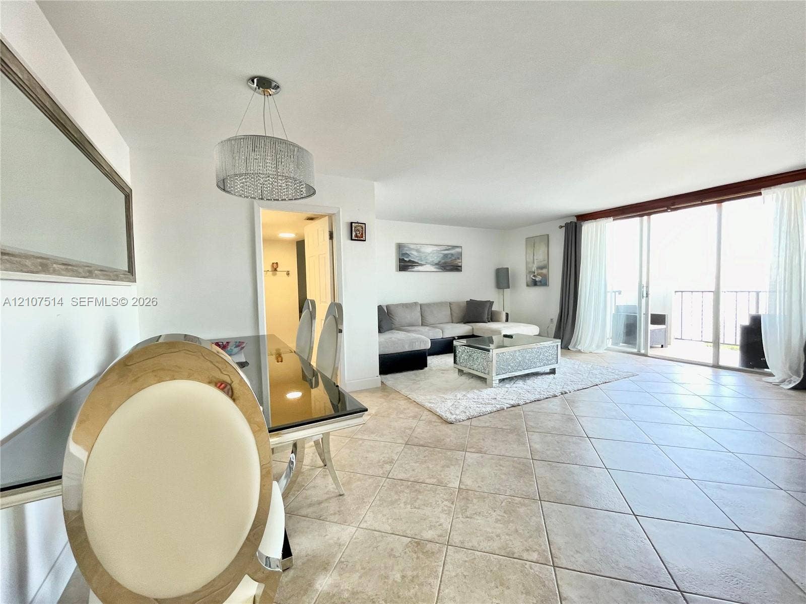 2750 NE 183rd Street, #2310, Aventura, Aventura, FL 33160 Open-concept interior featuring oversized floor tile, a drum-style pendant light fixture, and floor-to-ceiling sliding glass doors