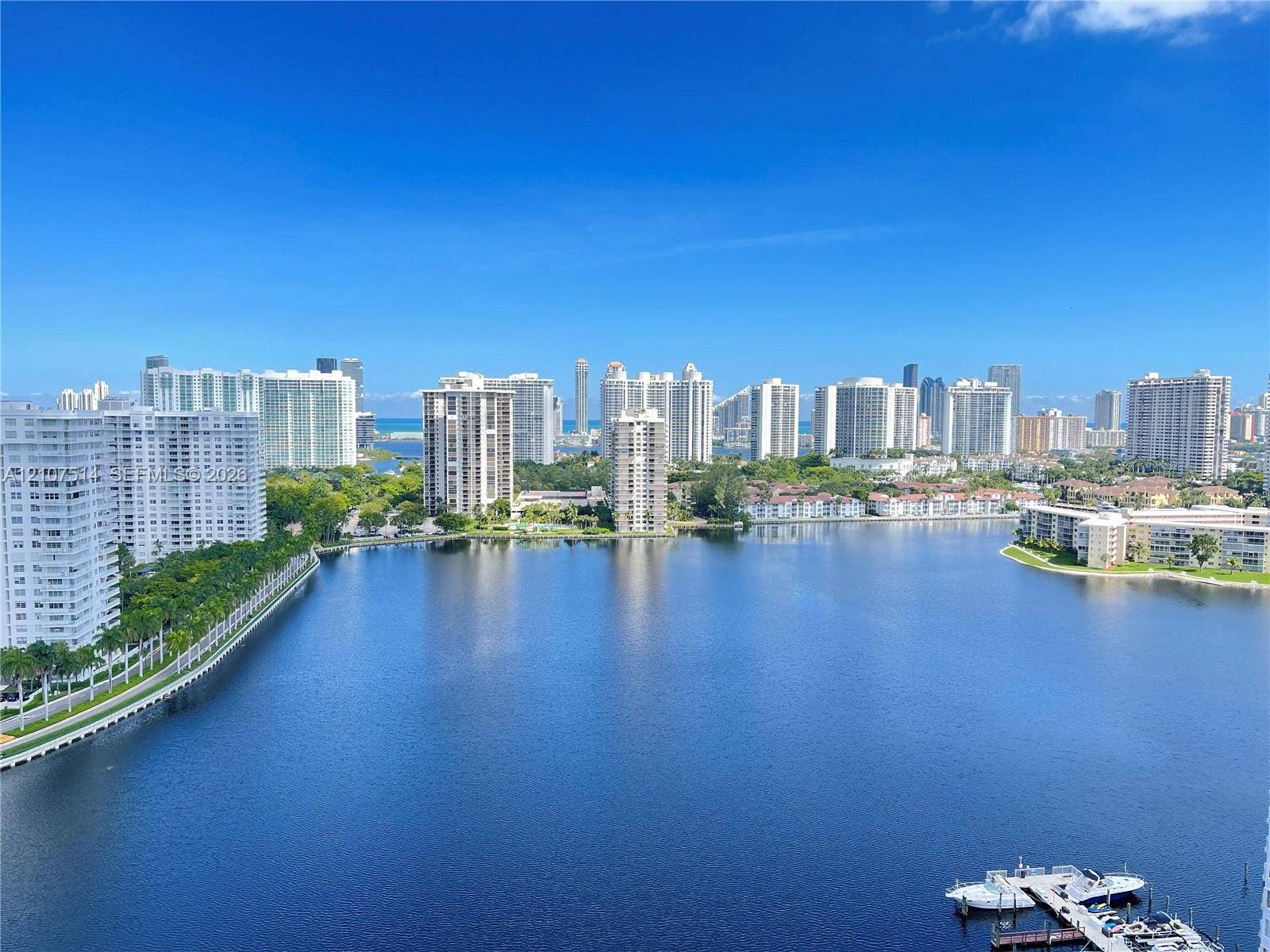 2750 NE 183rd Street, #2310, Aventura, Aventura, FL 33160 Expansive water frontage featuring a deep-water canal, boat docking structure, urban skyline backdrop, and dense perimeter landscaping