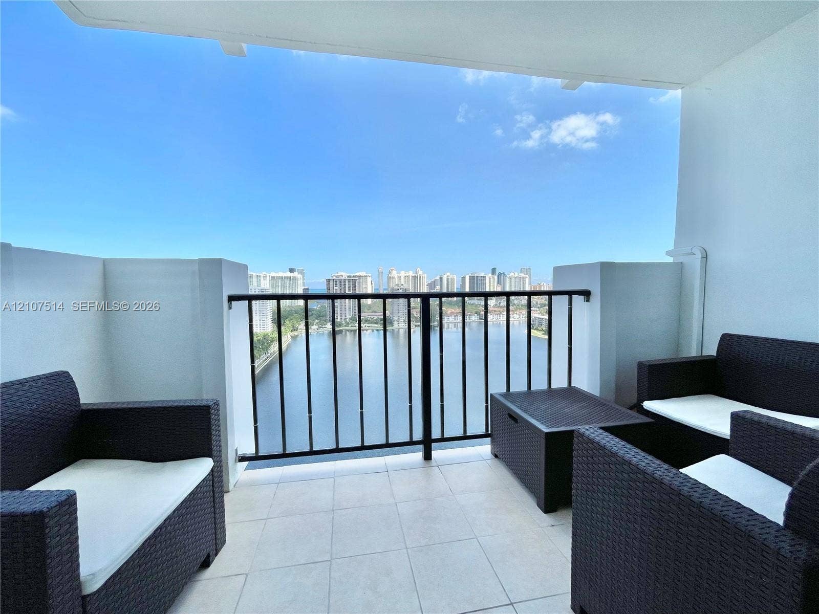 2750 NE 183rd Street, #2310, Aventura, Aventura, FL 33160 Private balcony featuring light-toned tile flooring and black metal railing, overlooking the water and surrounding city skyline