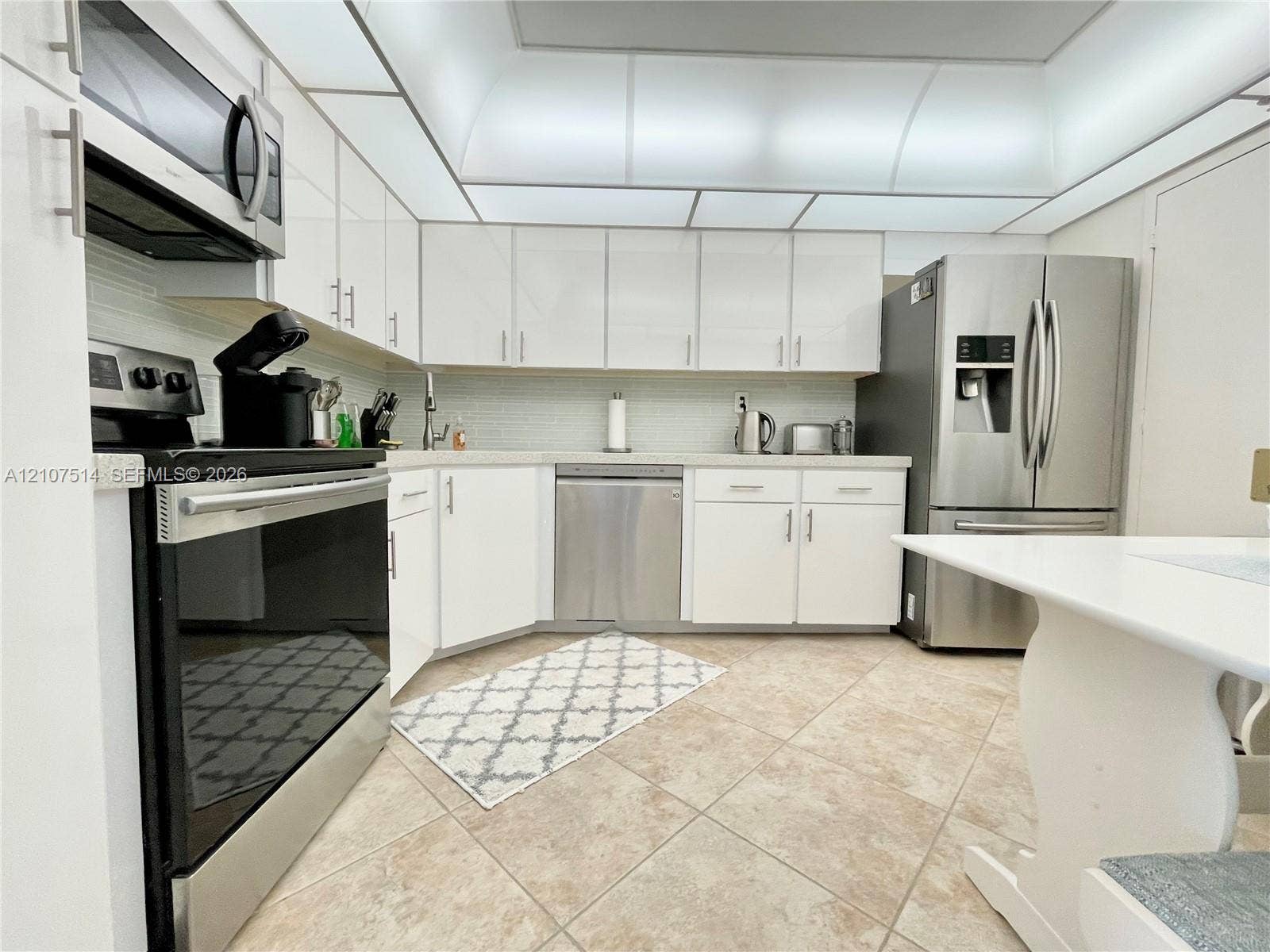 2750 NE 183rd Street, #2310, Aventura, Aventura, FL 33160 Kitchen featuring white cabinetry, stainless steel appliances, tile flooring, and integrated ceiling lighting