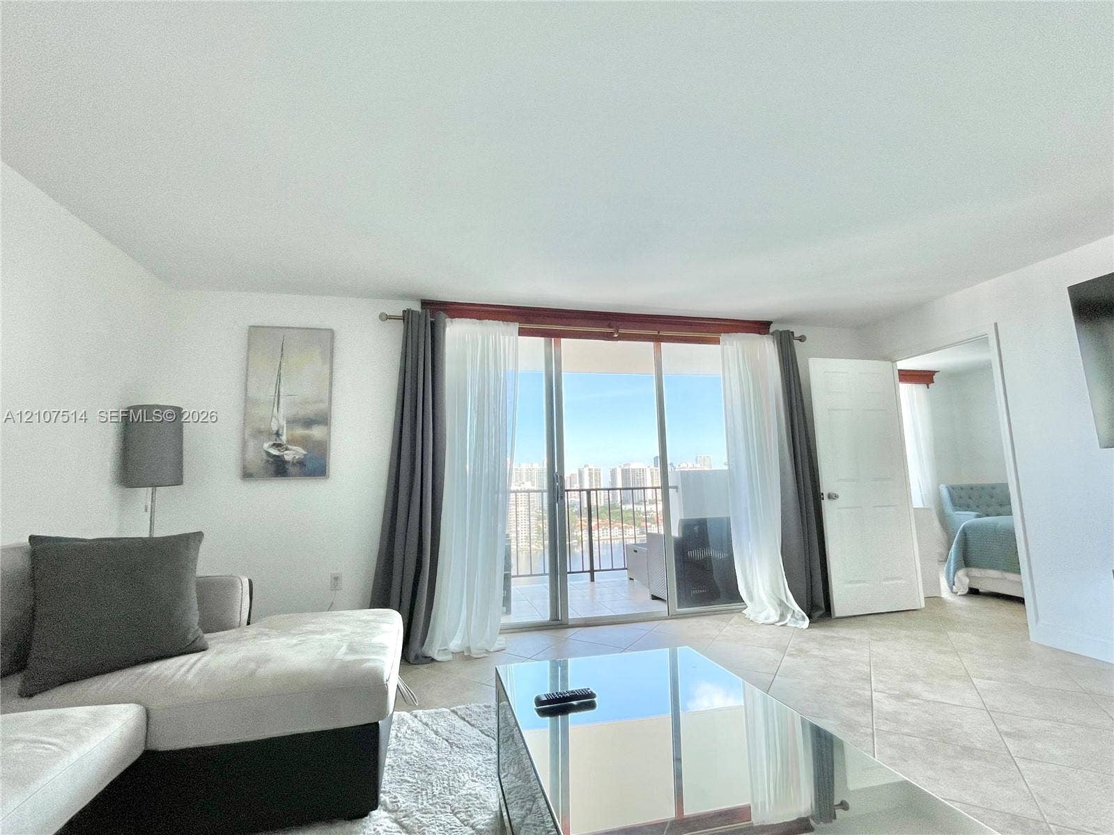 2750 NE 183rd Street, #2310, Aventura, Aventura, FL 33160 Sliding glass doors featuring floor-to-ceiling panels, neutral tile flooring, and a private balcony with metal railings