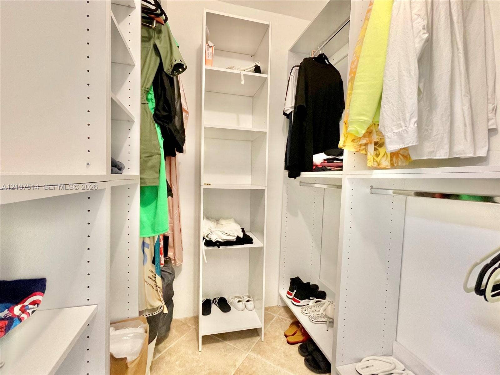 2750 NE 183rd Street, #2310, Aventura, Aventura, FL 33160 Custom walk-in closet featuring white built-in shelving, adjustable storage racks, metal hanging rods, and tile flooring