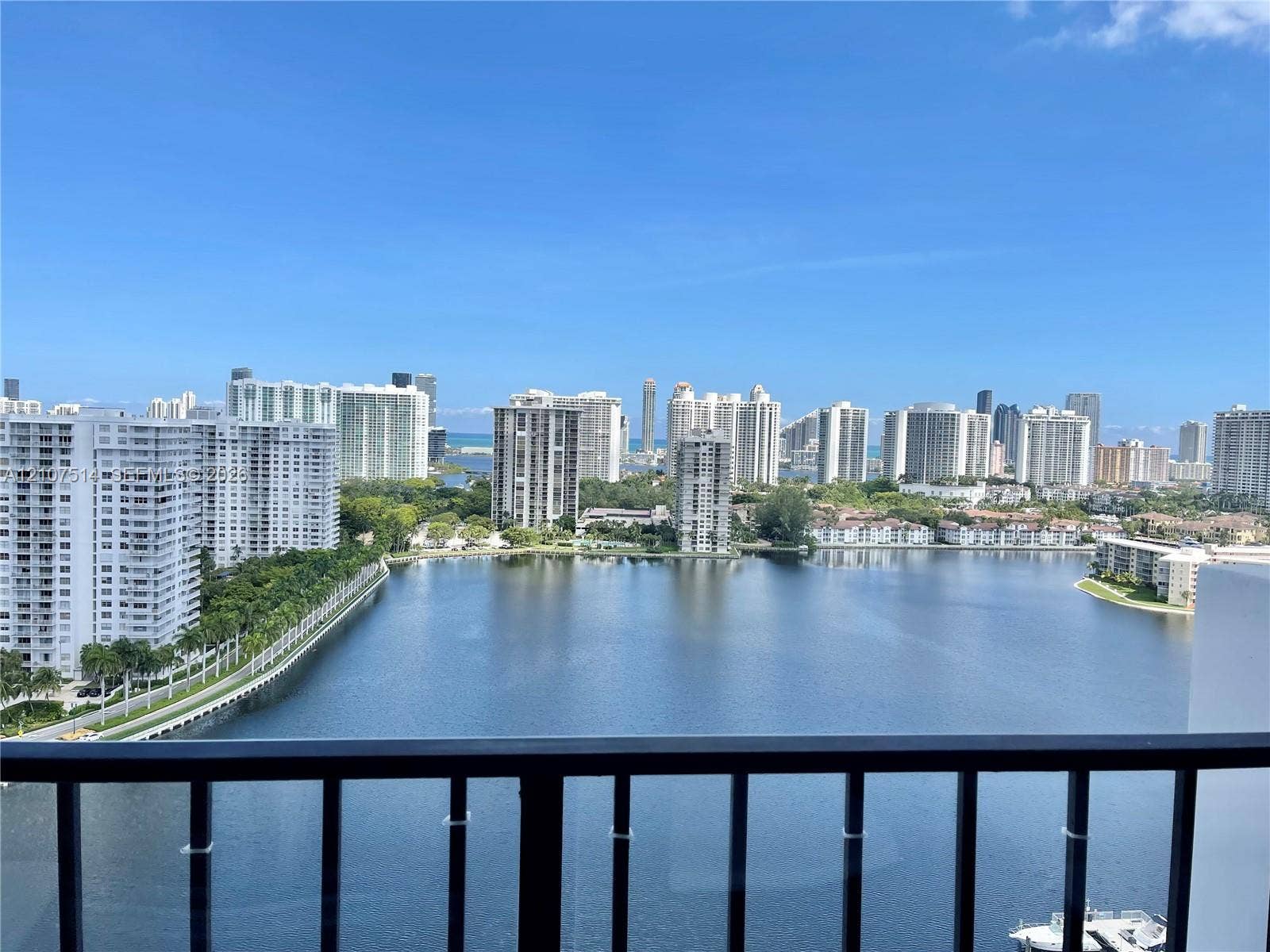 2750 NE 183rd Street, #2310, Aventura, Aventura, FL 33160 Black metal balcony railing overlooking a large lake and urban skyline