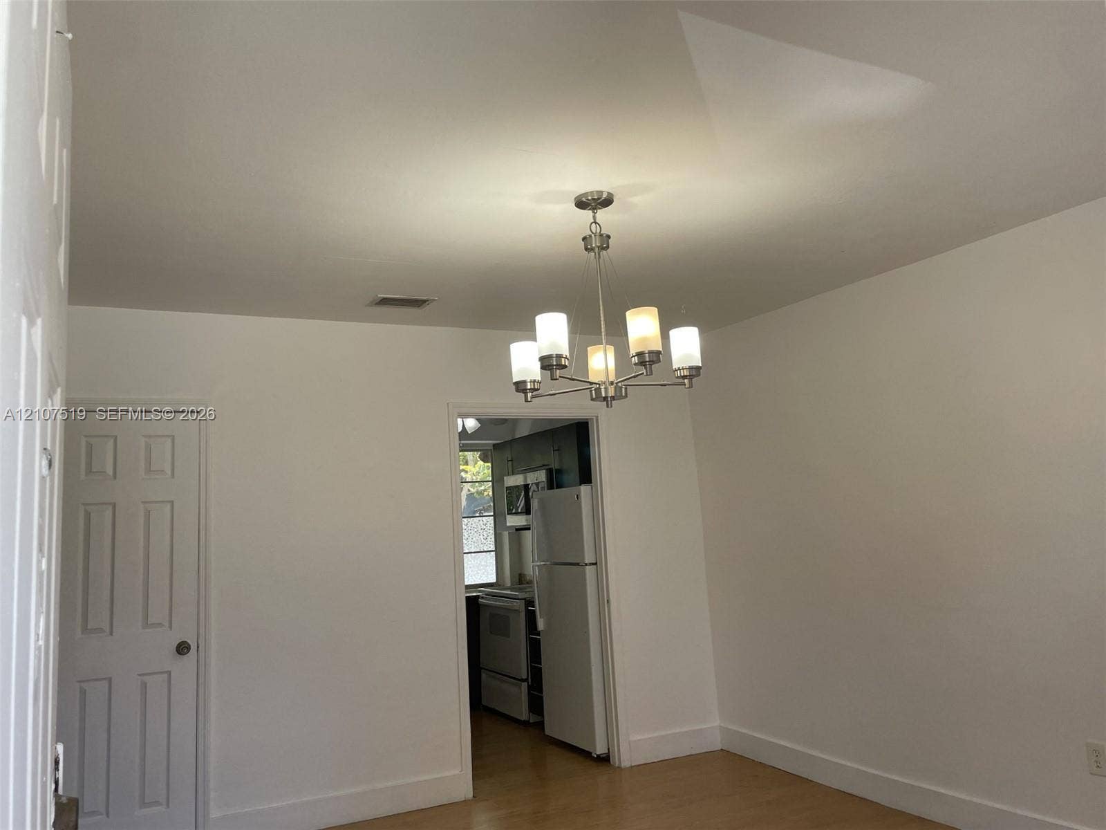 1201 SW 13th Street, #1205, Miami, Miami, FL 33145 Interior space featuring wood-finish flooring, a multi-arm chandelier with frosted glass shades, and a six-panel door