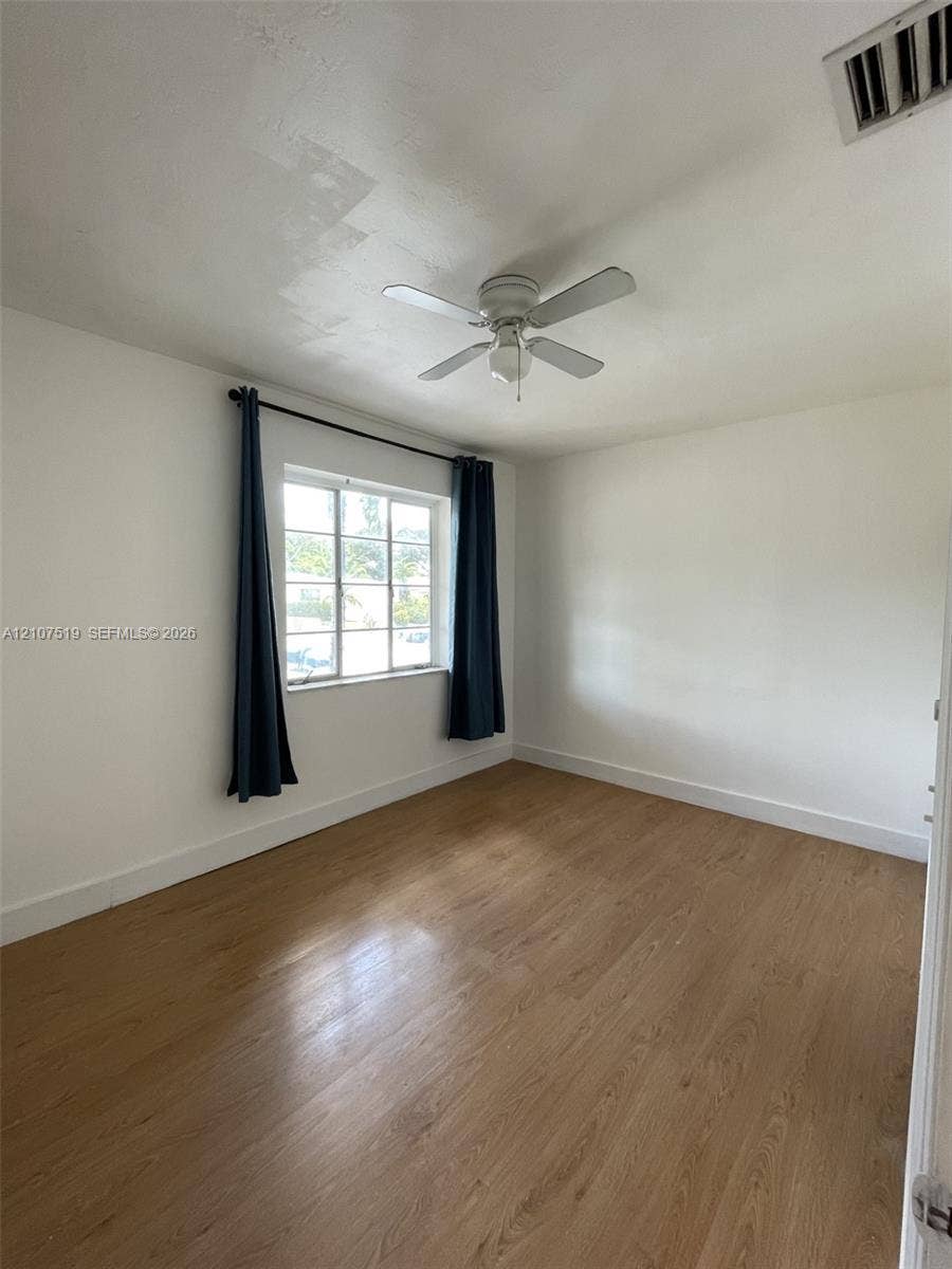1201 SW 13th Street, #1205, Miami, Miami, FL 33145 Room featuring wood-finish flooring, a multi-pane window, and a ceiling-mounted light fixture with fan