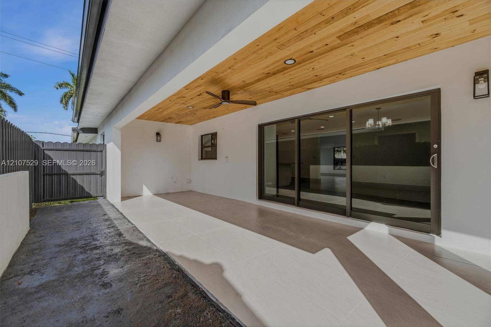 Covered patio featuring a wood-plank ceiling, large-format tile flooring, recessed lighting, ceiling fans, and sliding glass doors