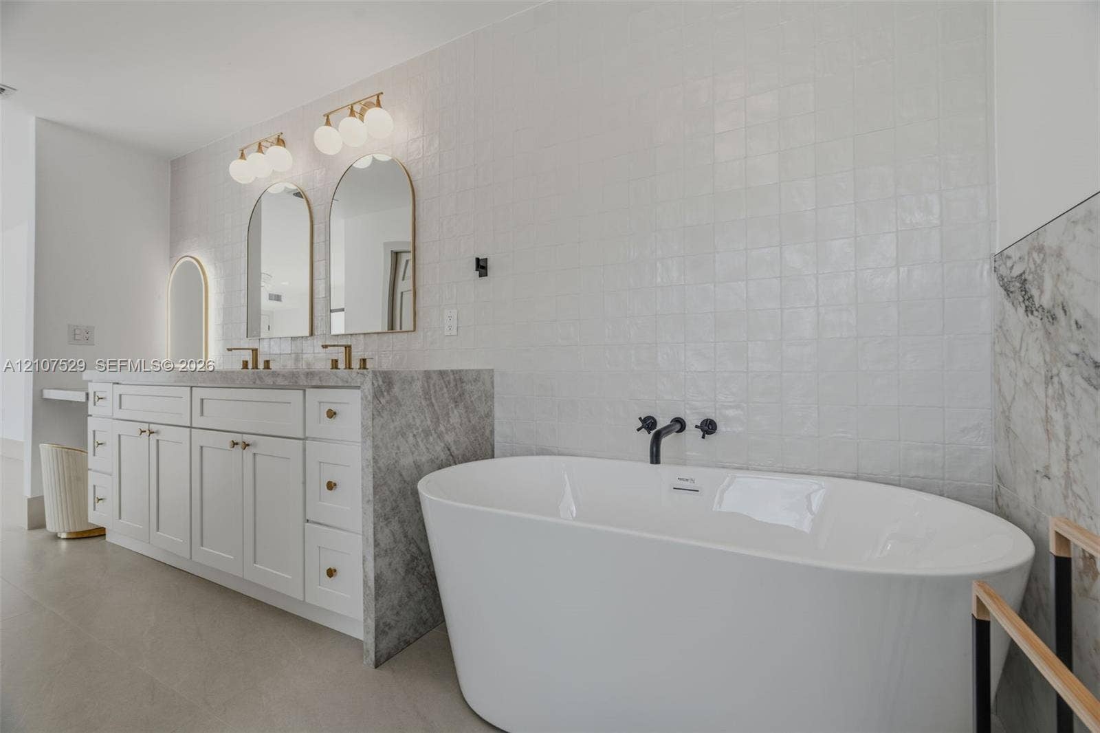 Walk-in shower featuring natural stone-finish wall tile, pebble-tiled flooring, a built-in bench, and matte black rain showerhead and handheld fixture