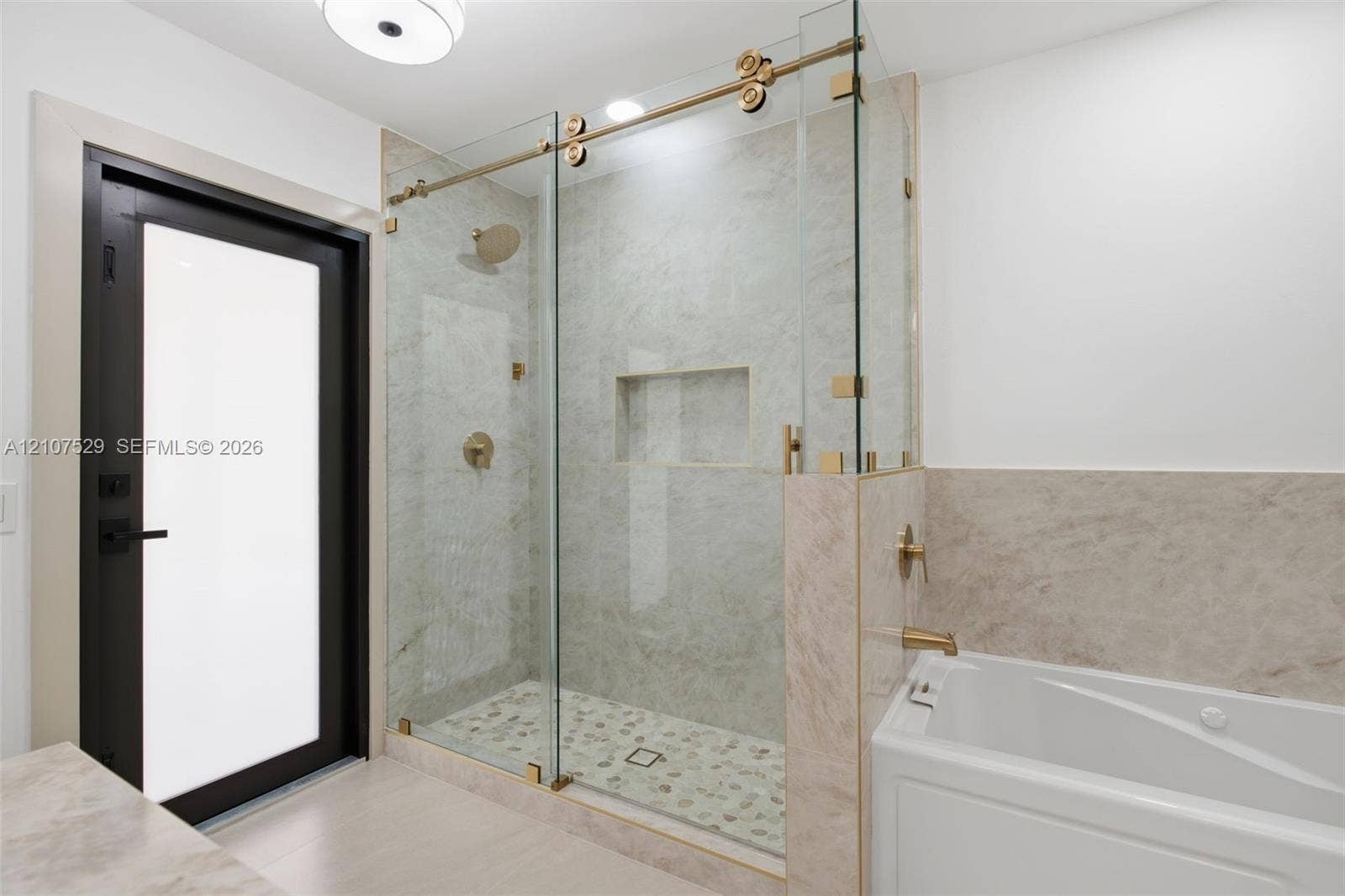 Neutral wall color, light-toned hard-surface flooring, black-framed windows, and a decorative tiered crystal chandelier