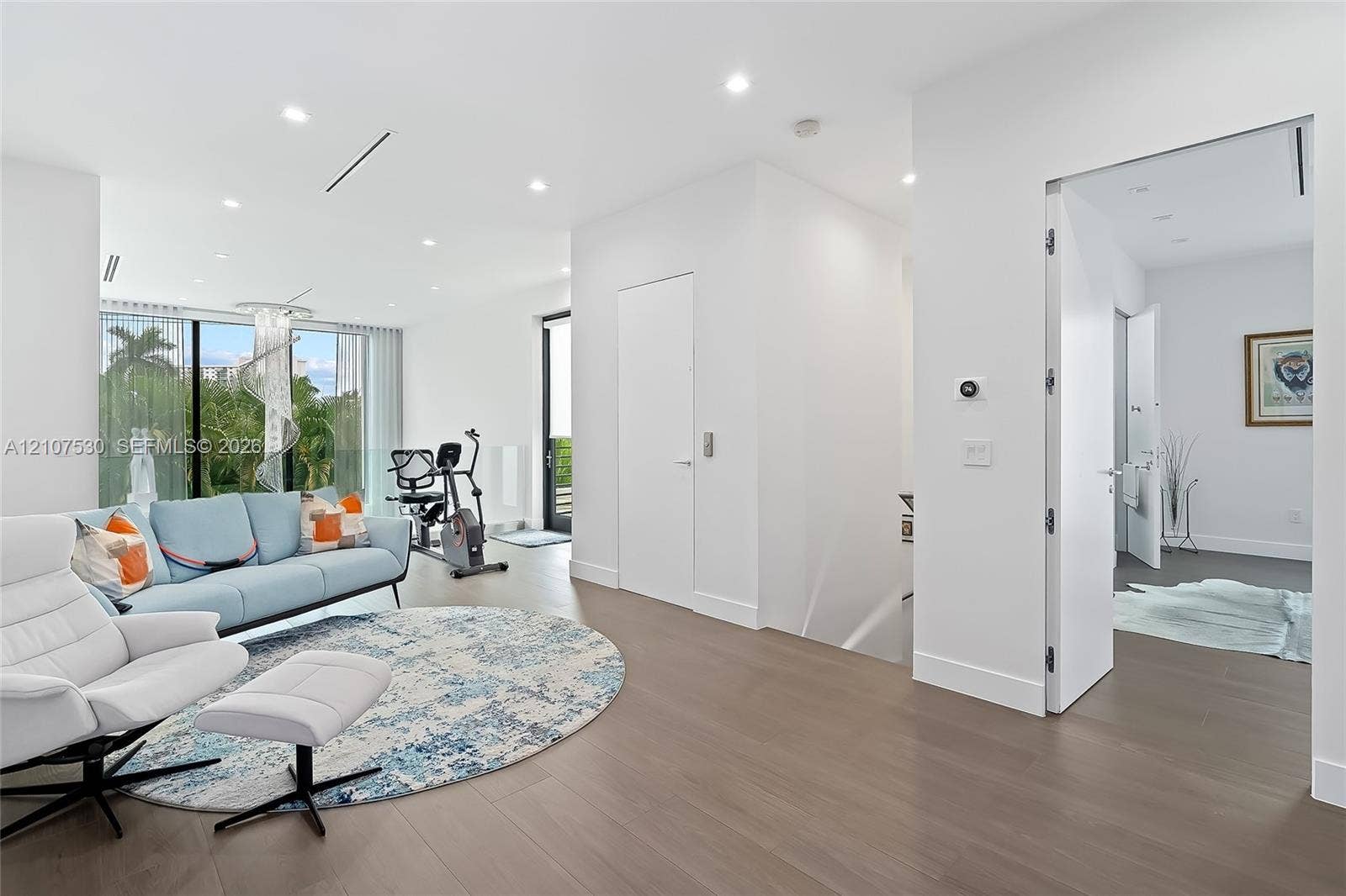 Interior space featuring wood-finish flooring, floor-to-ceiling glass windows, recessed ceiling lighting, and crisp white wall finishes