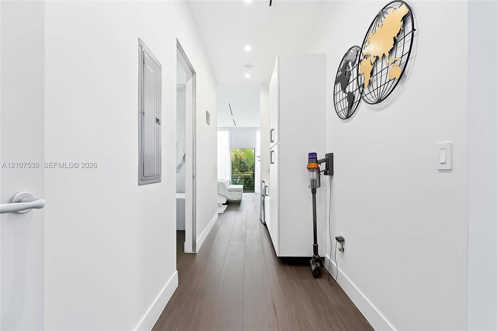 Hallway featuring wood-finish flooring, recessed lighting, and built-in white cabinetry