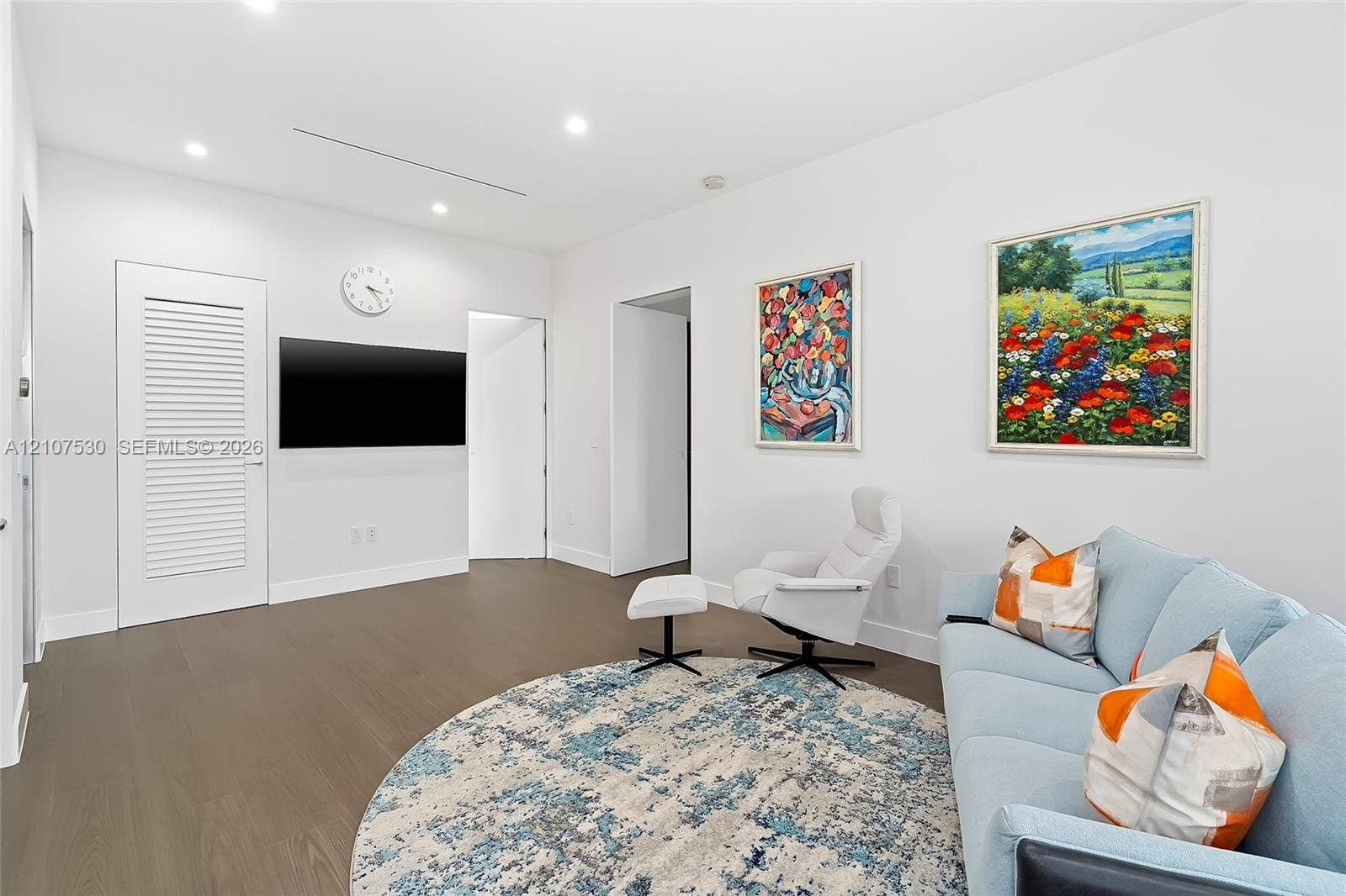 Neutral-toned interior featuring wood-finish flooring, recessed lighting, and a louvered-panel door