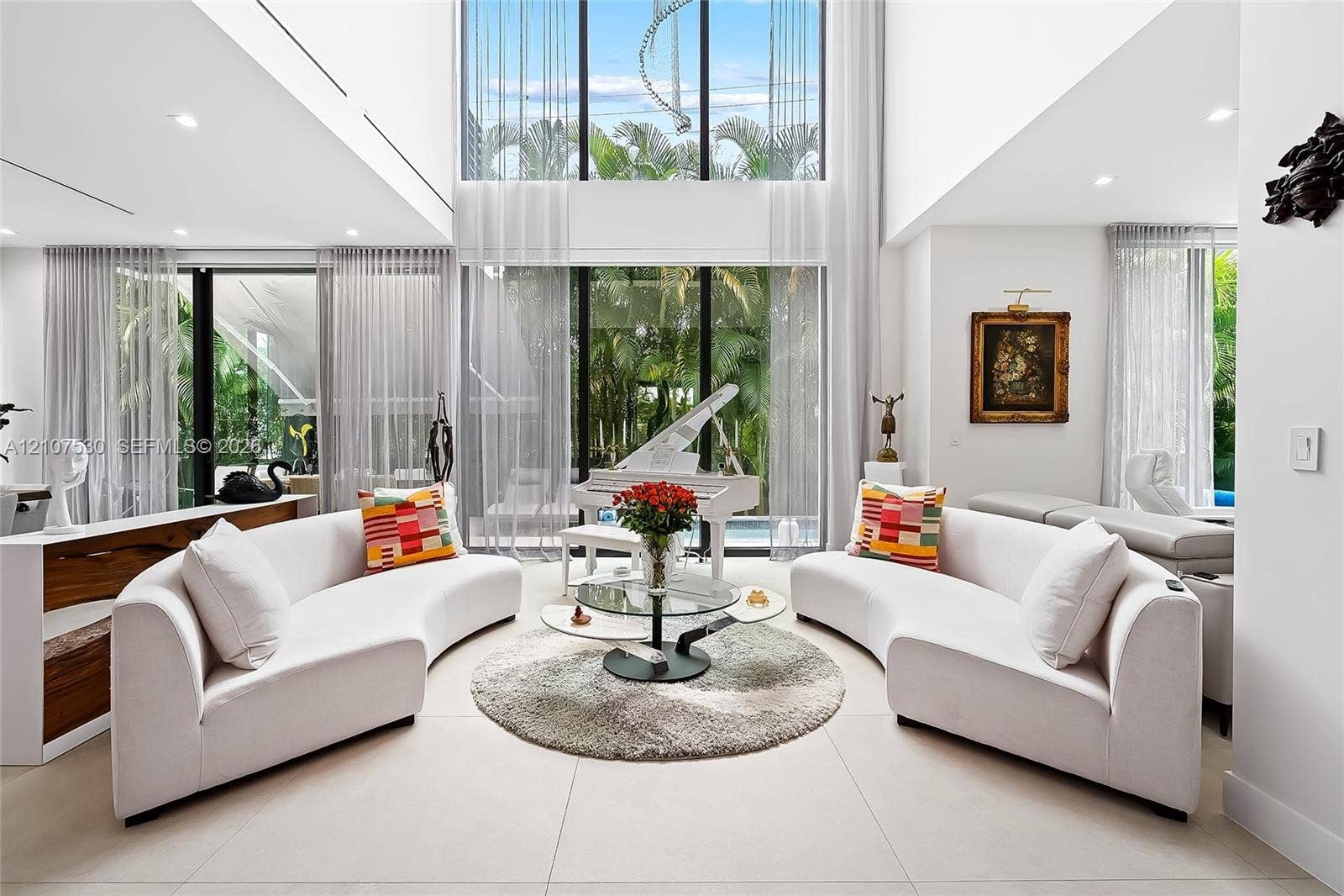 Double-height ceilings featuring floor-to-ceiling glass walls, large-format tile flooring, and integrated recessed lighting