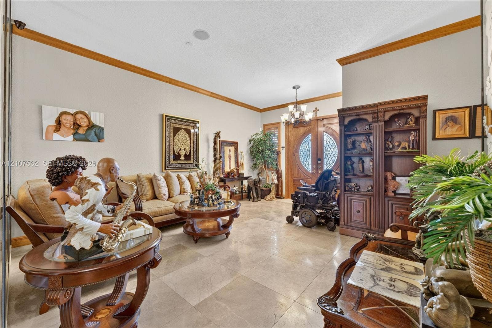 9124 NW 147th Terrace, Miami Lakes, FL 33018 Large-format tile flooring, crown molding, built-in wooden cabinetry, multi-light chandelier, and double-entry doors with decorative glass inserts