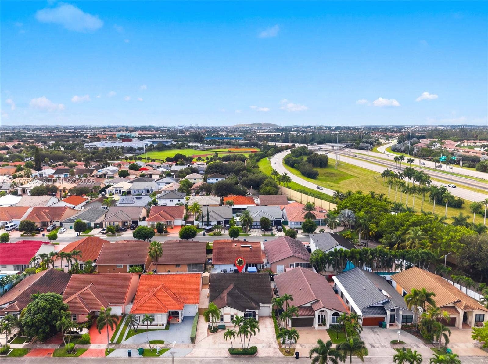 9124 NW 147th Terrace, Miami Lakes, FL 33018 Aerial perspective of residential properties featuring varied roof pitches, concrete driveways, and mature landscaping