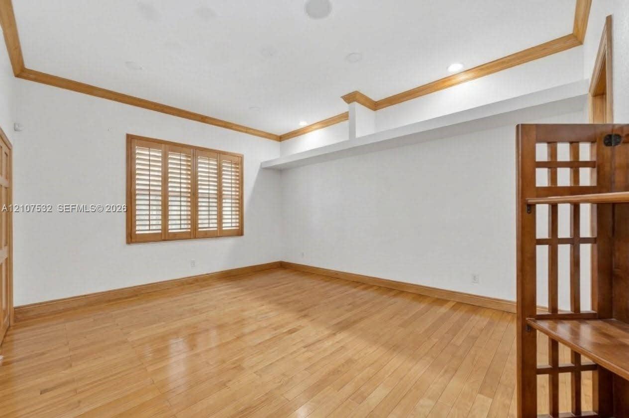 9124 NW 147th Terrace, Miami Lakes, FL 33018 Interior space featuring wood-finish flooring, ceiling crown molding, wood-framed window shutters, recessed lighting, and a built-in recessed shelf