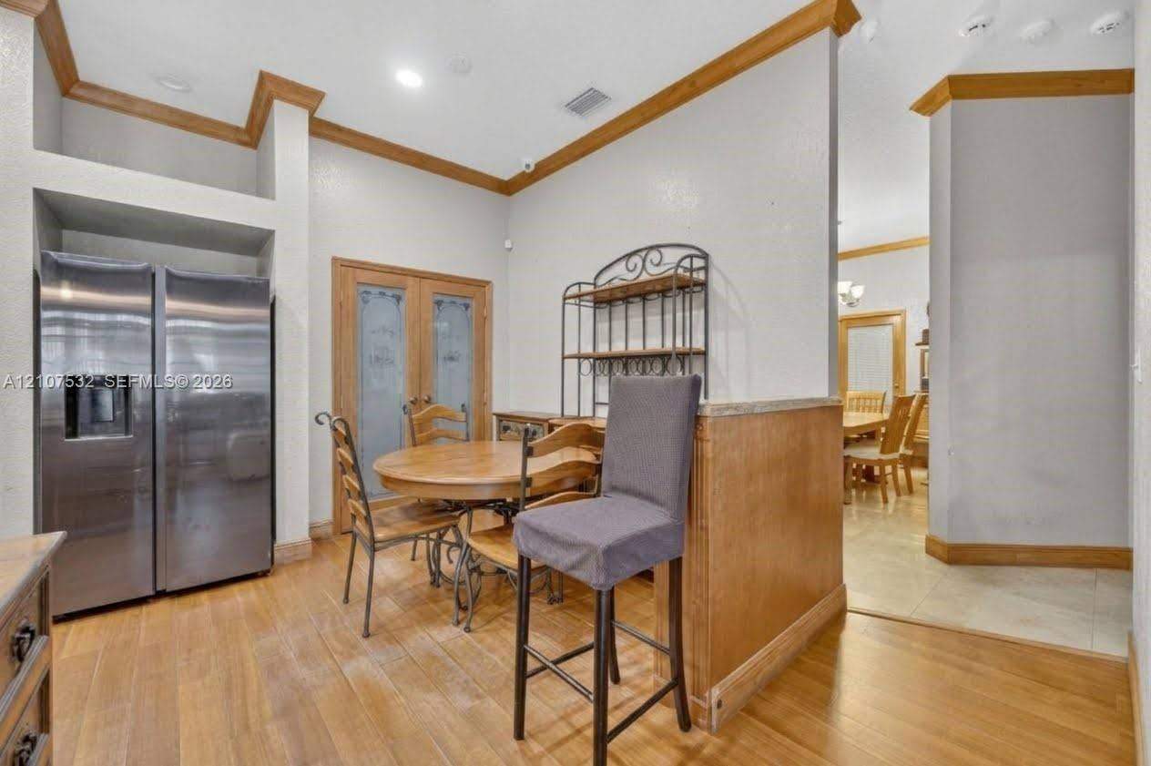 9124 NW 147th Terrace, Miami Lakes, FL 33018 Stainless steel side-by-side refrigerator, wood-finish flooring, recessed lighting, crown molding, and glass-paneled double doors