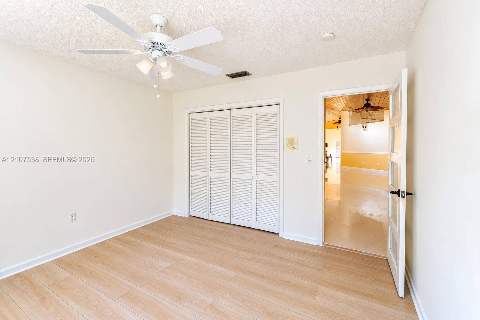 10204 SW 96th Court, Miami, Miami, FL 33176 Room featuring wood-finish flooring, a white ceiling fan with integrated lighting, and louvered bifold closet doors
