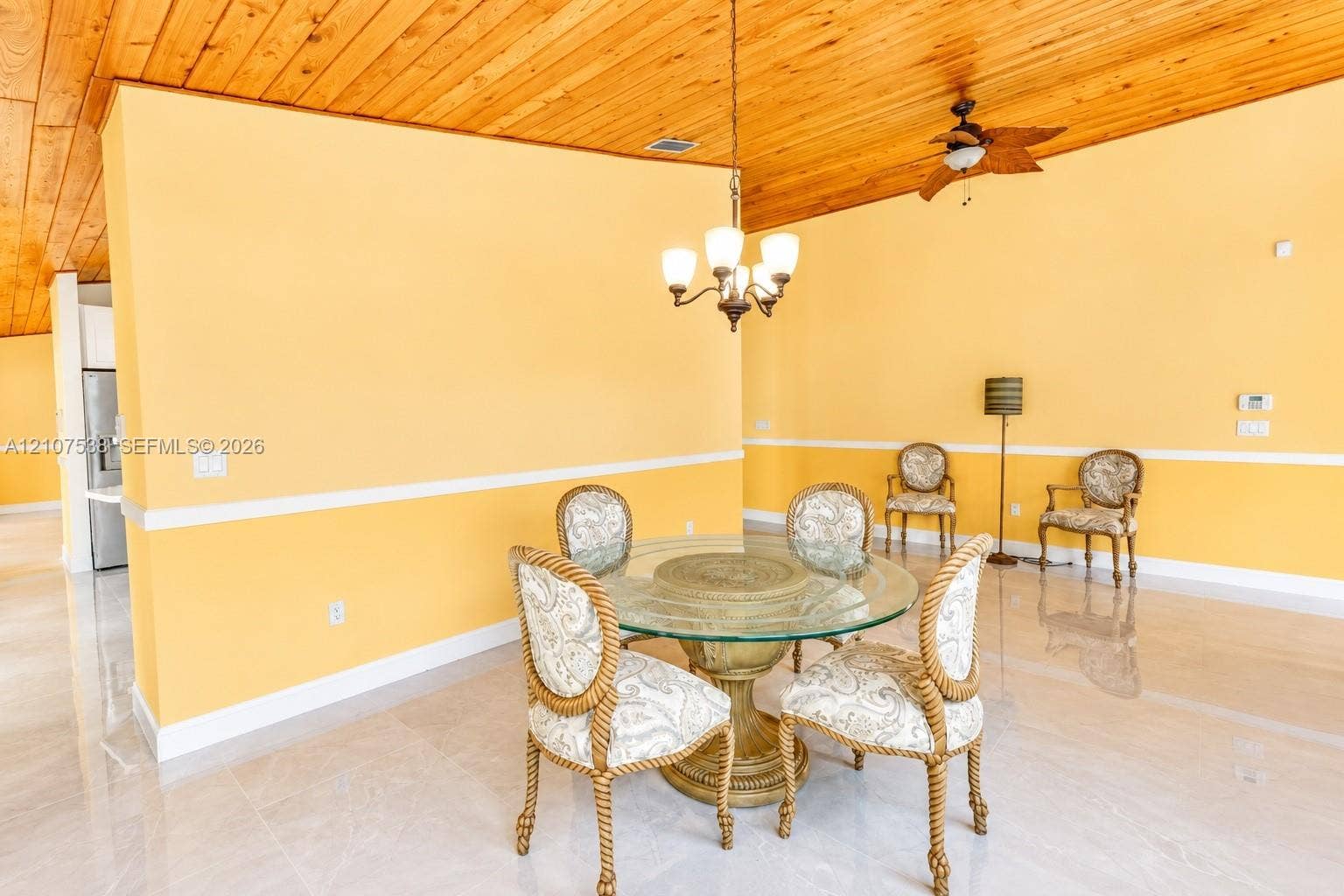 10204 SW 96th Court, Miami, Miami, FL 33176 Vaulted tongue-and-groove wood ceiling, polished tile flooring, white chair rail molding, and multi-light hanging chandelier