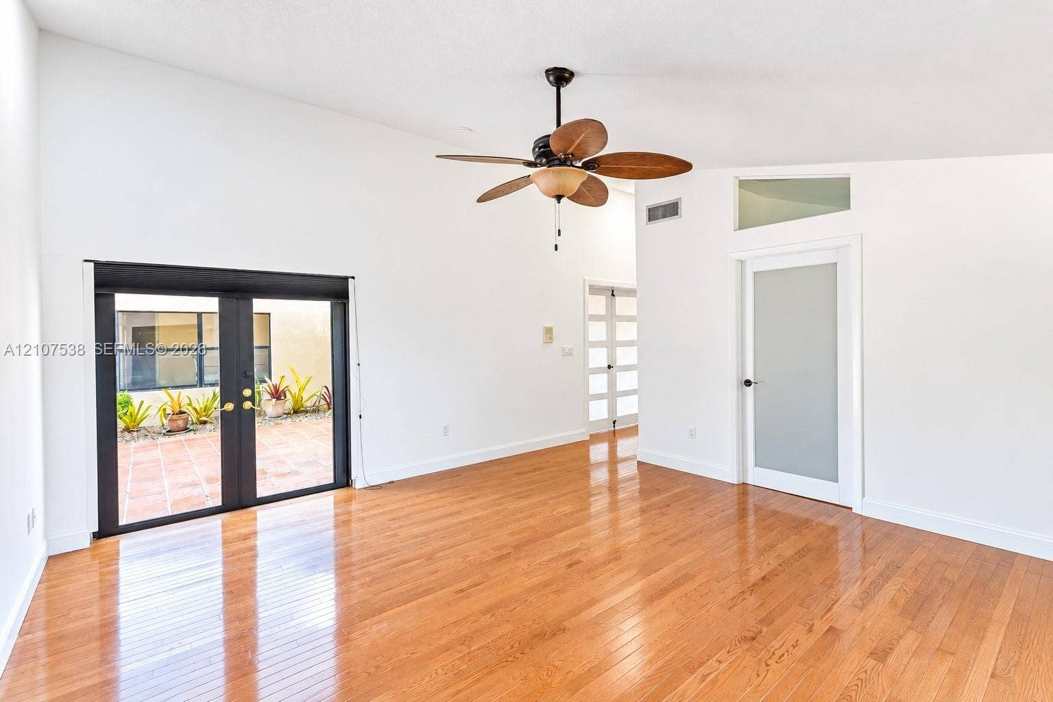 10204 SW 96th Court, Miami, Miami, FL 33176 Vaulted ceilings, wood-finish flooring, French doors with exterior access, and a frosted glass panel door with an integrated transom window