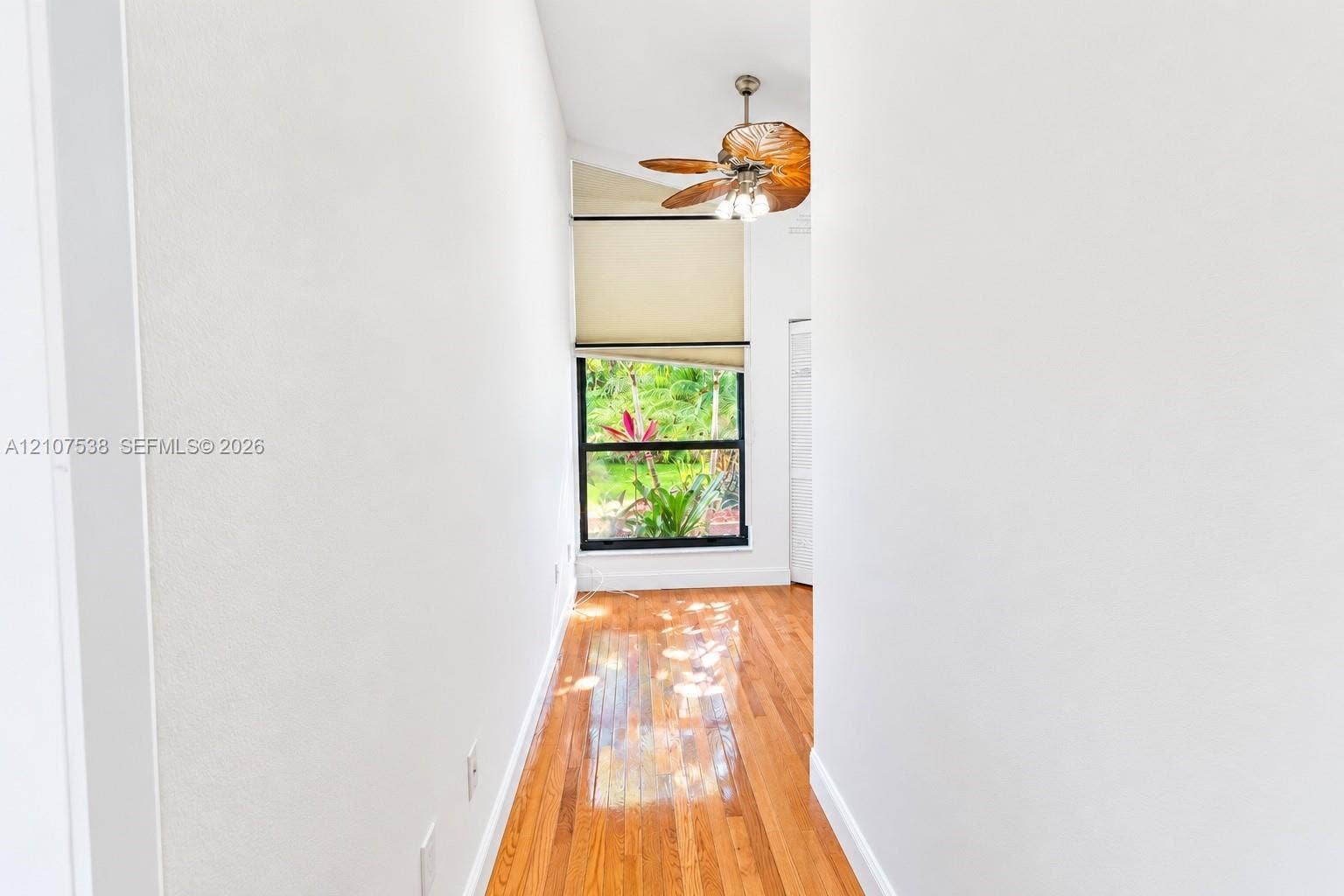 10204 SW 96th Court, Miami, Miami, FL 33176 Interior space featuring wood-finish flooring, vaulted ceiling, built-in paddle ceiling fan with integrated lighting, and a window with black trim