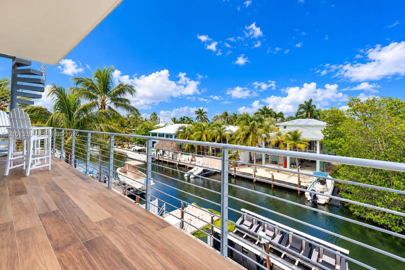 20 Center Lane, Key Largo, FL 33037 Elevated deck with wood-finish flooring, metal cable railing, and a spiral staircase