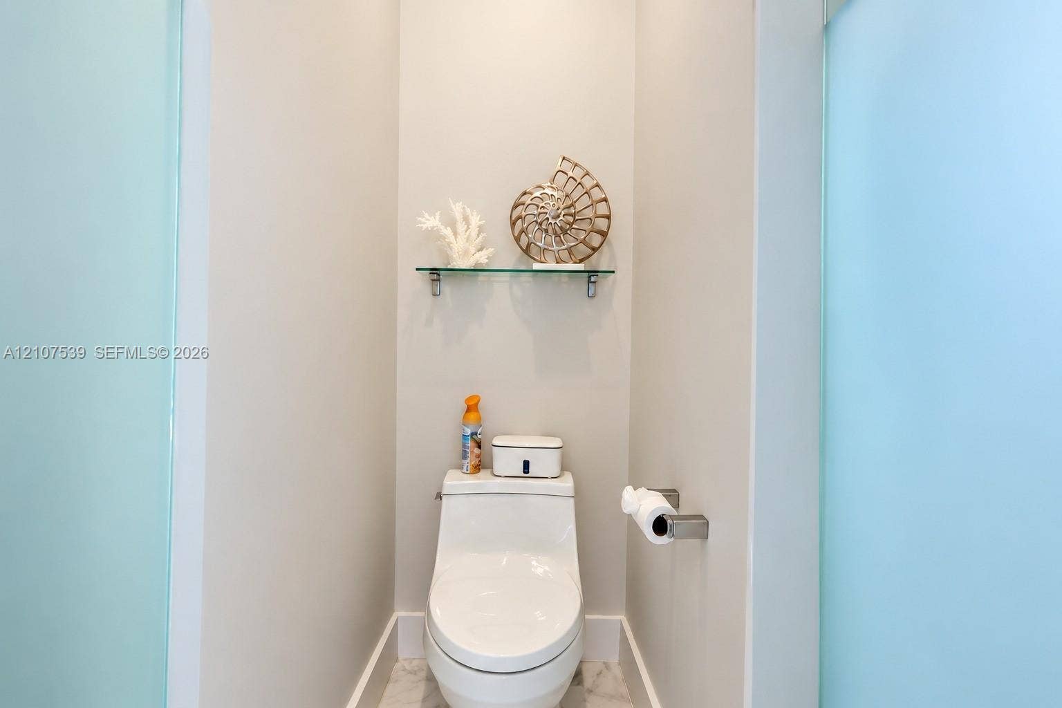20 Center Lane, Key Largo, FL 33037 Wall-mounted glass shelving, one-piece dual-flush toilet, and frosted glass privacy panels