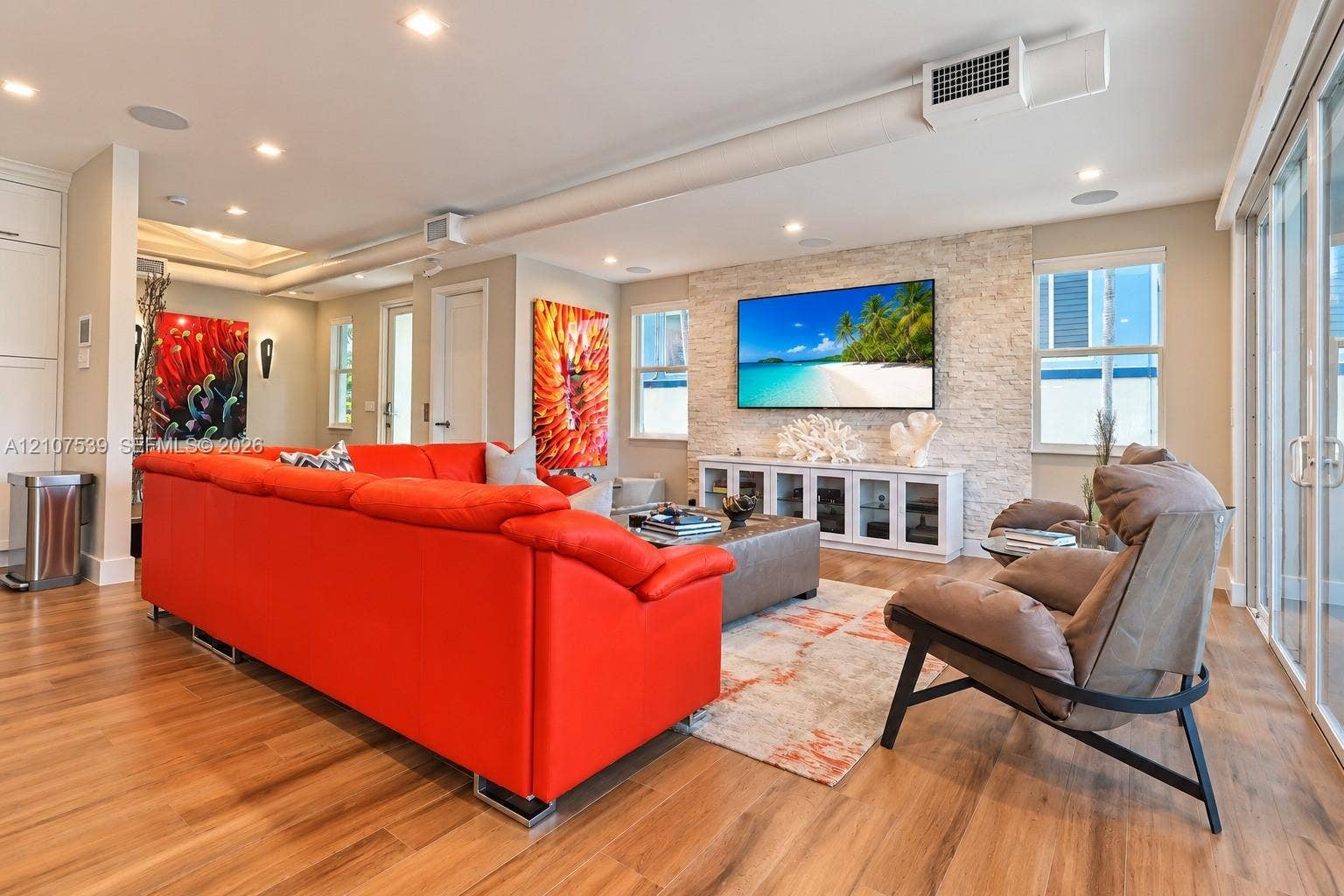 20 Center Lane, Key Largo, FL 33037 Living area featuring recessed lighting, wood-finish flooring, a textured stone accent wall, and glass sliding doors