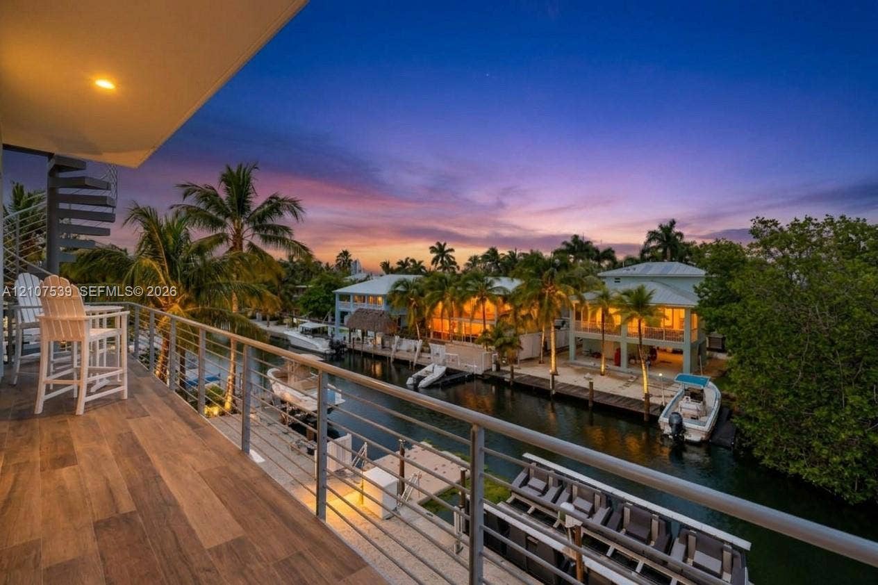 20 Center Lane, Key Largo, FL 33037 Covered balcony featuring wood-finish flooring, metal railing, and spiral staircase