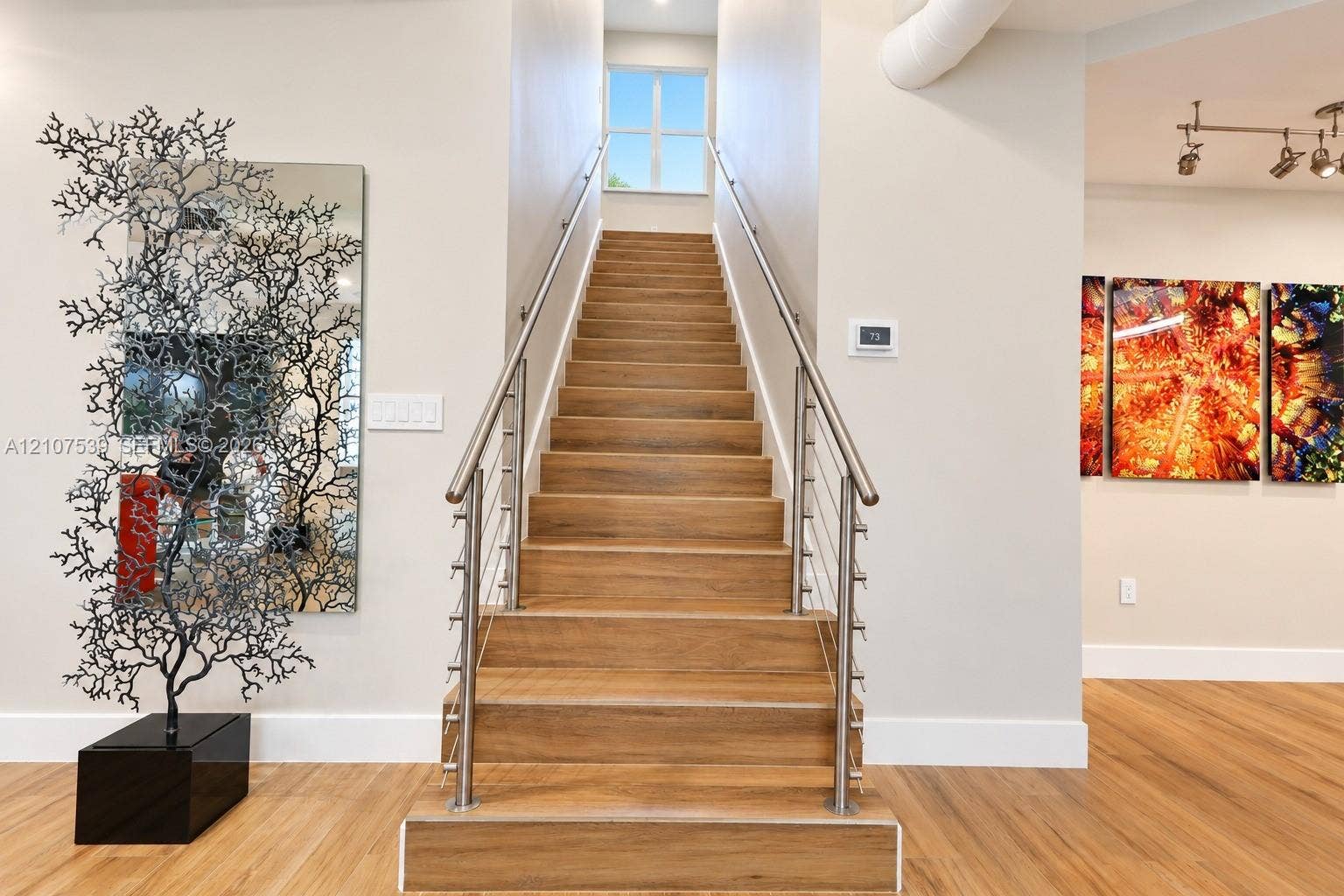 20 Center Lane, Key Largo, FL 33037 Staircase featuring wood-finish treads, stainless steel cable railings, and a metal handrail