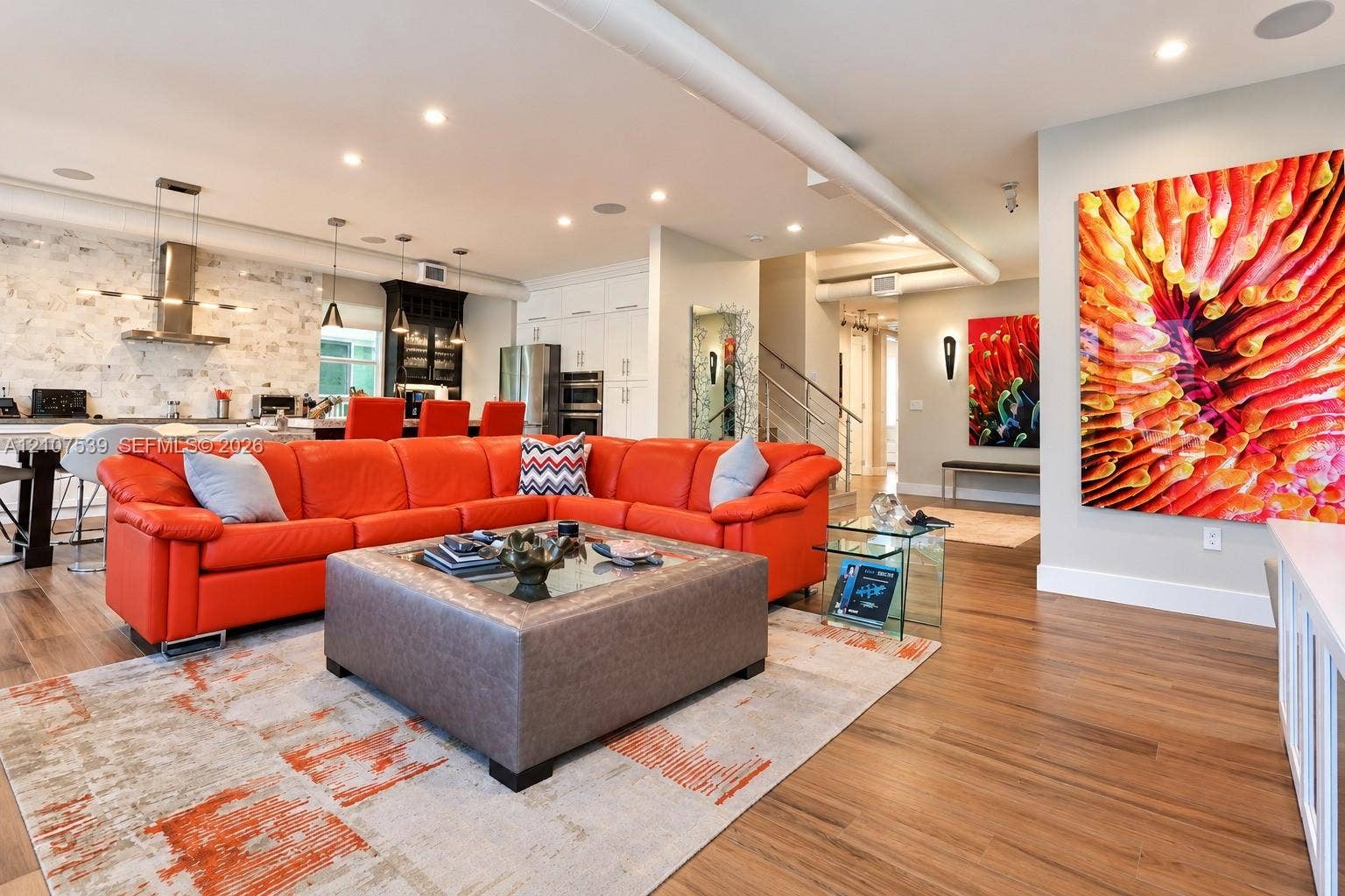20 Center Lane, Key Largo, FL 33037 Open-concept interior featuring wood-finish flooring, recessed lighting, a stainless steel range hood, stone-style backsplash, and white cabinetry