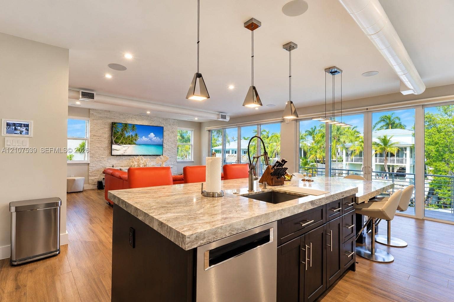20 Center Lane, Key Largo, FL 33037 Center island with stone countertop, dark cabinetry, stainless steel dishwasher, recessed lighting, and metal pendant fixtures