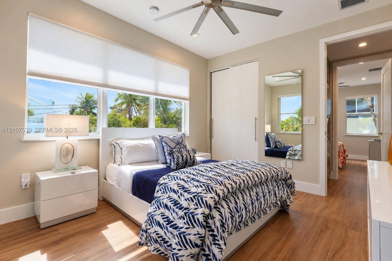 20 Center Lane, Key Largo, FL 33037 Wood-finish flooring, large windows with neutral roller shades, ceiling fan with light fixture, and built-in closet with sliding doors