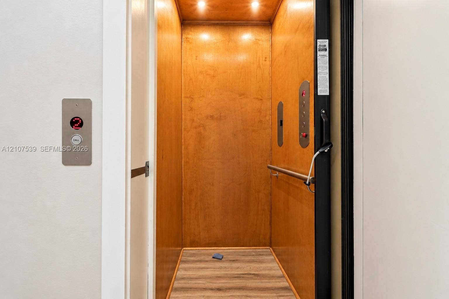 20 Center Lane, Key Largo, FL 33037 Private elevator featuring wood-paneled interior walls, integrated ceiling lighting, horizontal metal handrail, and wood-finish flooring