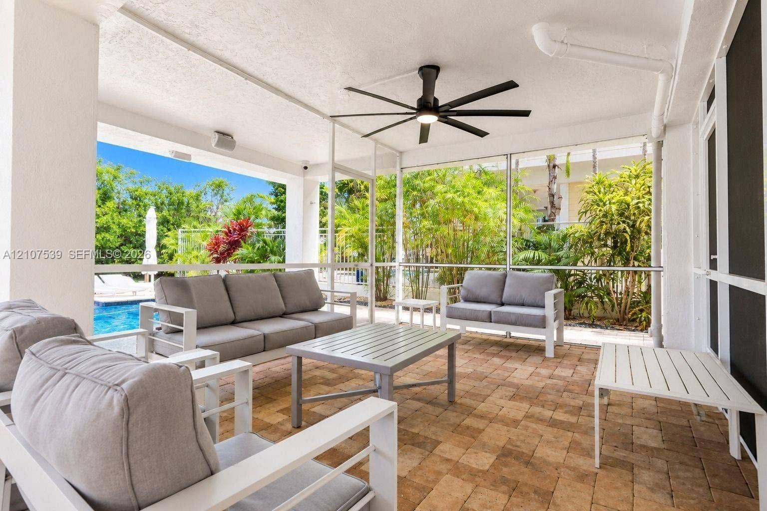 20 Center Lane, Key Largo, FL 33037 Covered screened lanai featuring paver flooring, a ceiling fan with integrated lighting, and structural columns