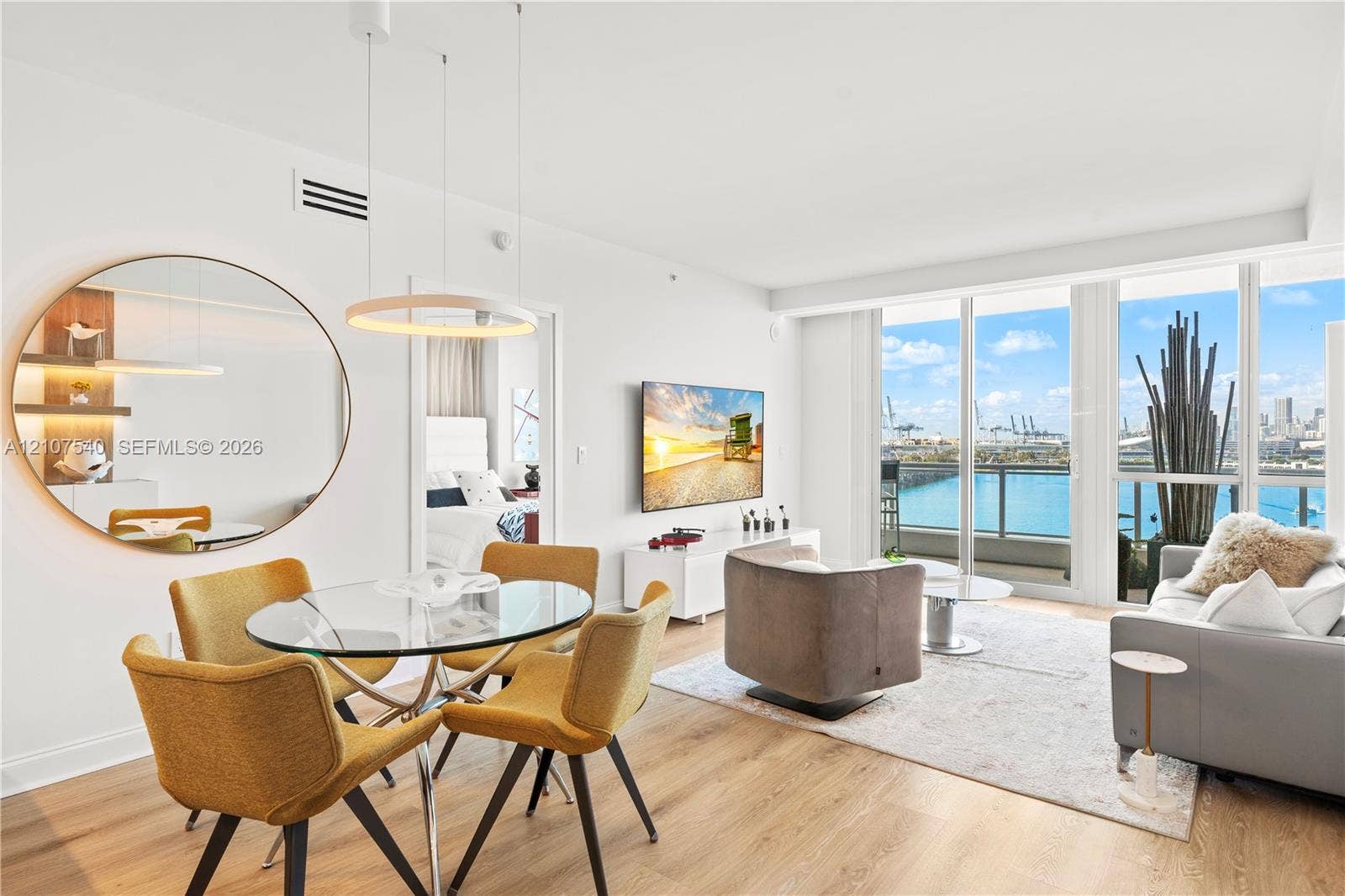 Open-concept professionally remodeled & appointed living space featuring top of the line Porcelanosa wood-finish flooring & floor-to-ceiling windows with downtown Miami skyline views