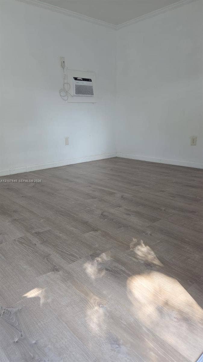 6431 Hayes Street, #3, Hollywood, Hollywood, FL 33024 Neutral interior space featuring wood-finish flooring and a wall-mounted cooling unit