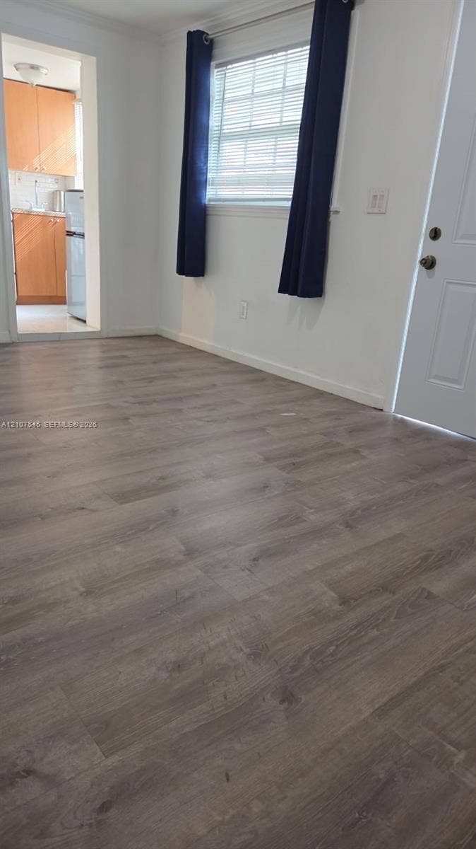6431 Hayes Street, #3, Hollywood, Hollywood, FL 33024 Wood-finish flooring, white walls, horizontal blind window treatment, and six-panel interior door