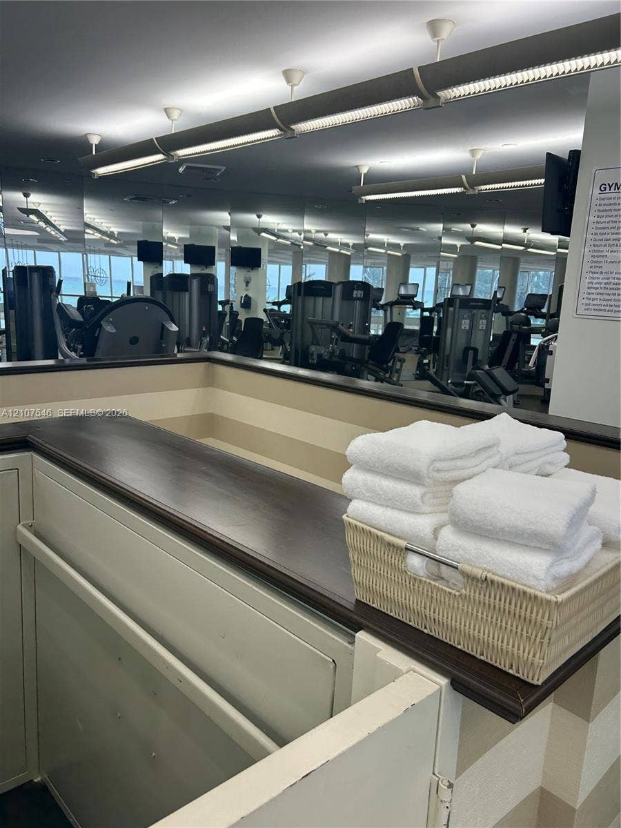 19333 Collins Avenue, #2007, Sunny Isles Beach, Sunny Isles Beach, FL 33160 Fitness area featuring full-wall mirrors, recessed lighting, and a built-in service counter with a dark wood-finish top